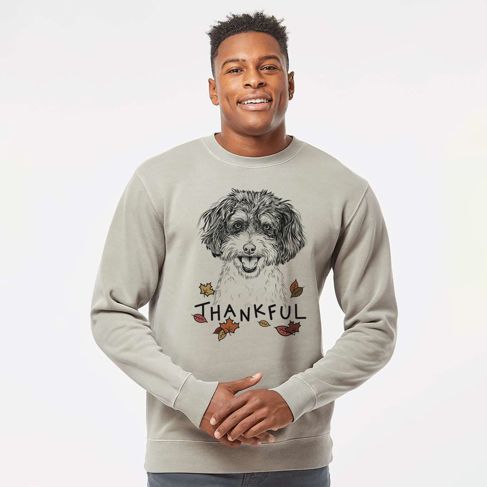 Hand-drawn sketch of Carlos the Cavapoo with 'Thankful' lettering and autumn leaves on a Cement Unisex pigment dyed crew sweatshirt