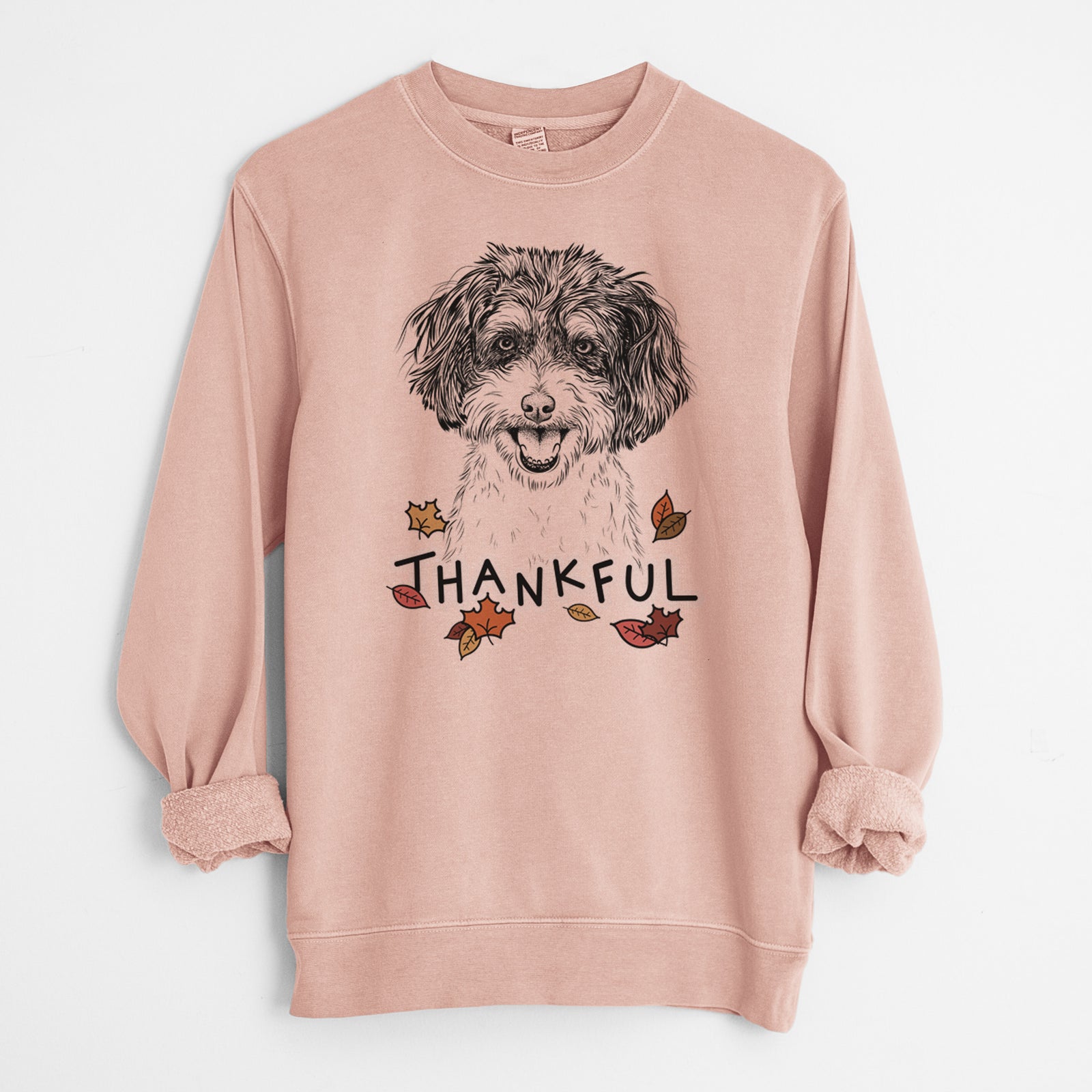 Hand-drawn sketch of Carlos the Cavapoo with 'Thankful' lettering and autumn leaves on a Dusty Pink Unisex pigment dyed crew sweatshirt