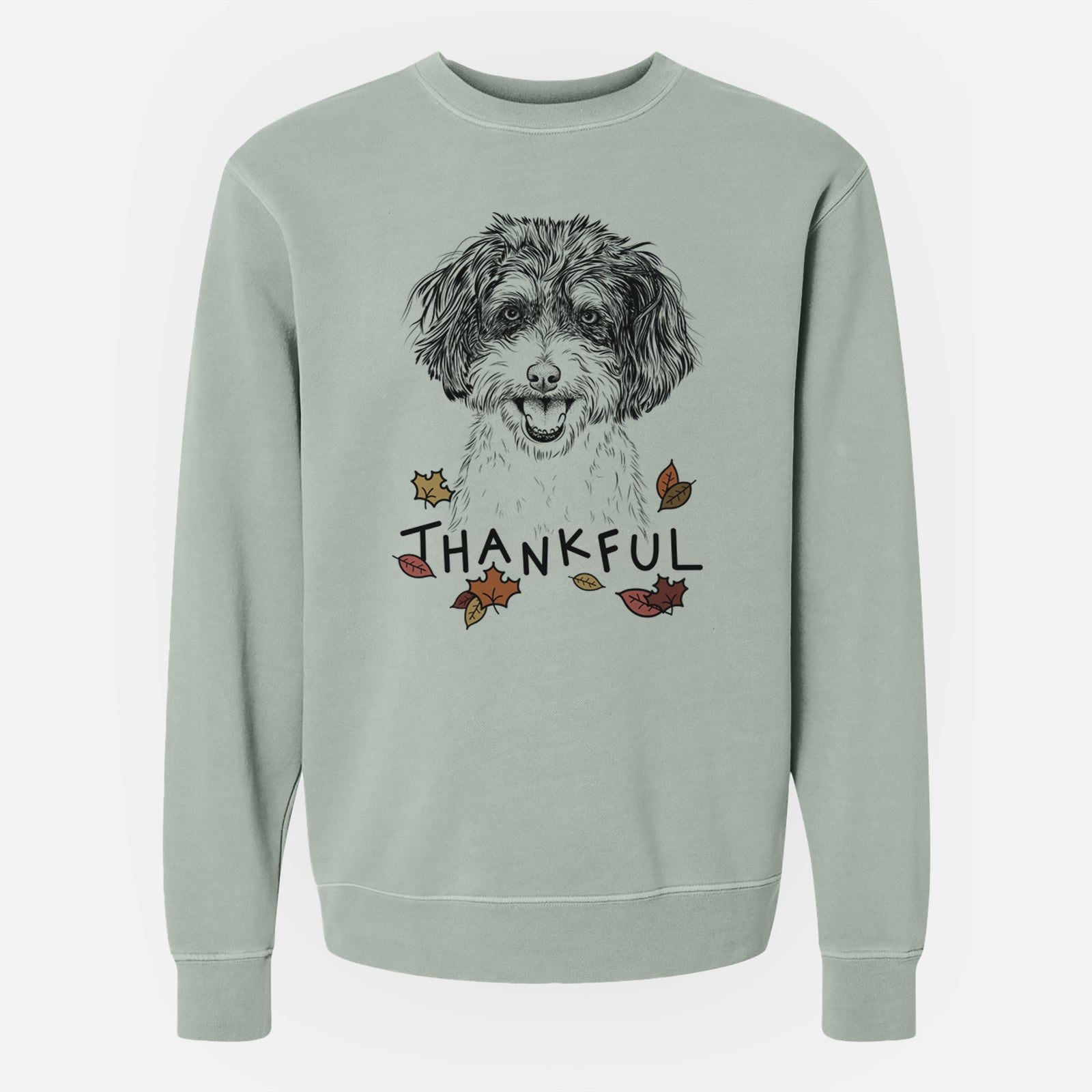 Hand-drawn sketch of Carlos the Cavapoo with 'Thankful' lettering and autumn leaves on a Sage Unisex pigment dyed crew sweatshirt