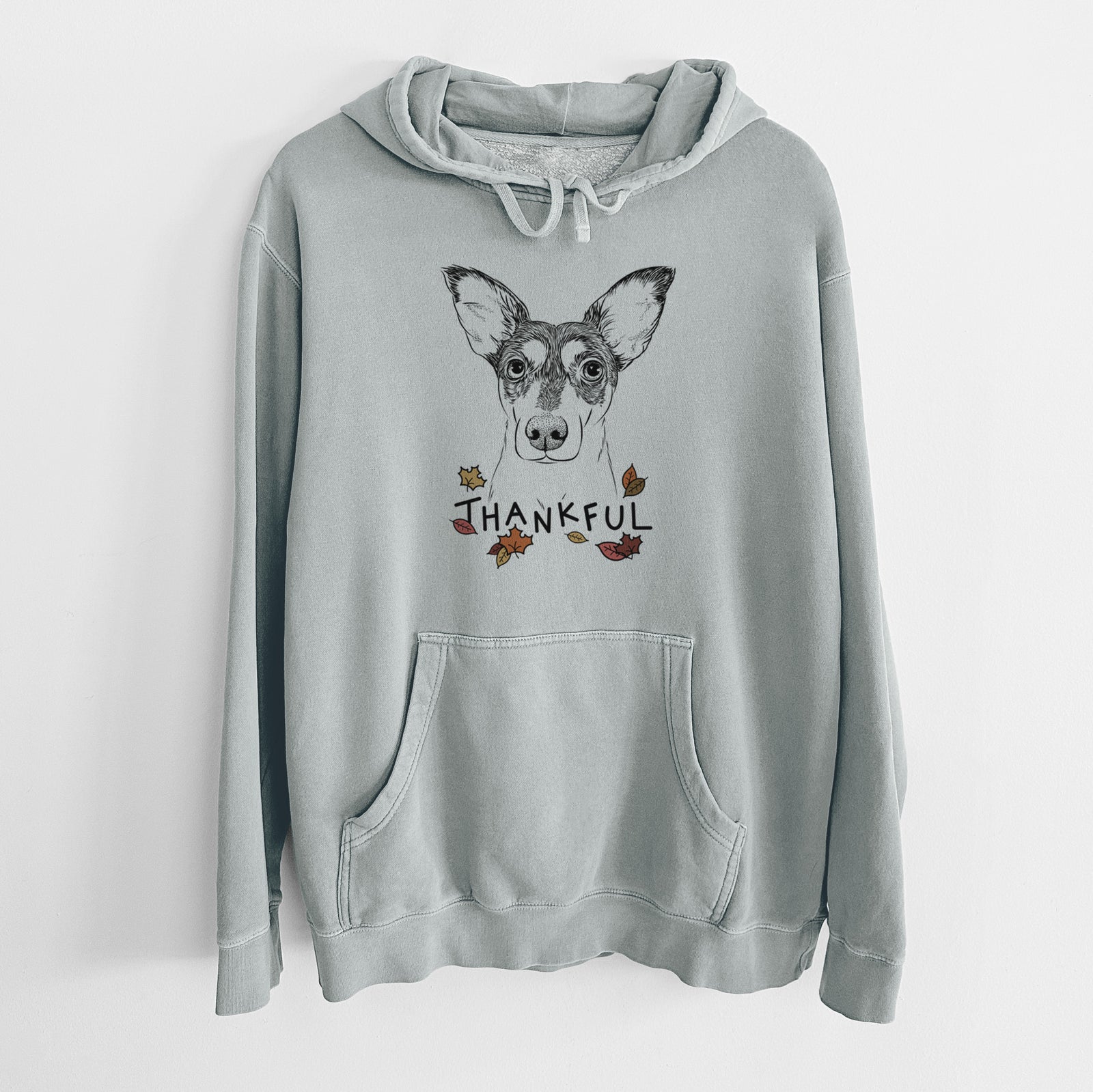 Hand-drawn sketch of Chloe the Doxie Mix with 'Thankful' lettering and autumn leaves on a Sage Unisex pigment dyed hoodie