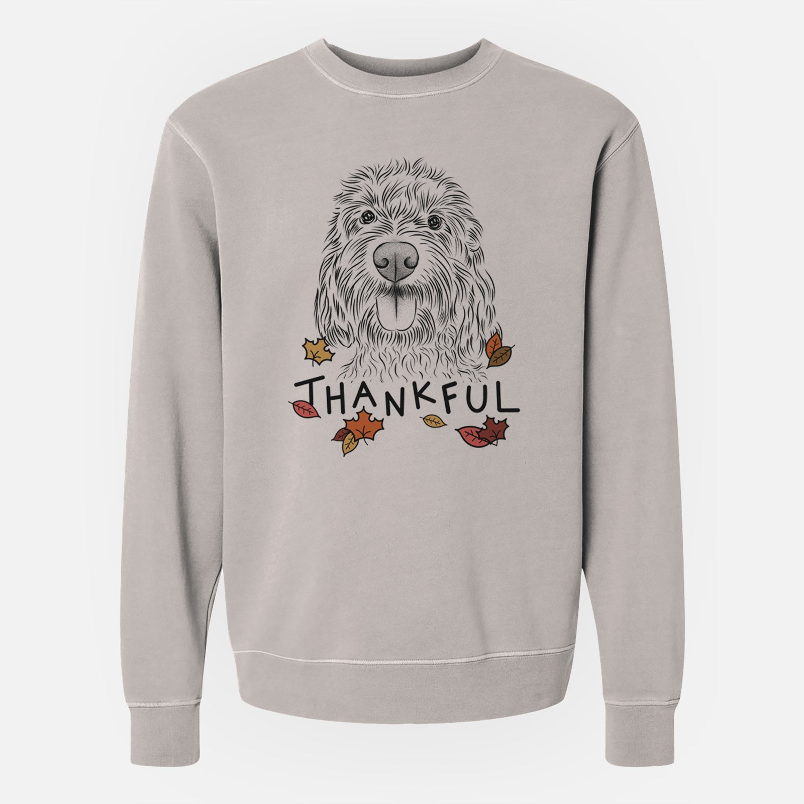 Hand-drawn sketch of Clover the Cockapoo with 'Thankful' lettering and autumn leaves on a Cement Unisex pigment dyed crew sweatshirt