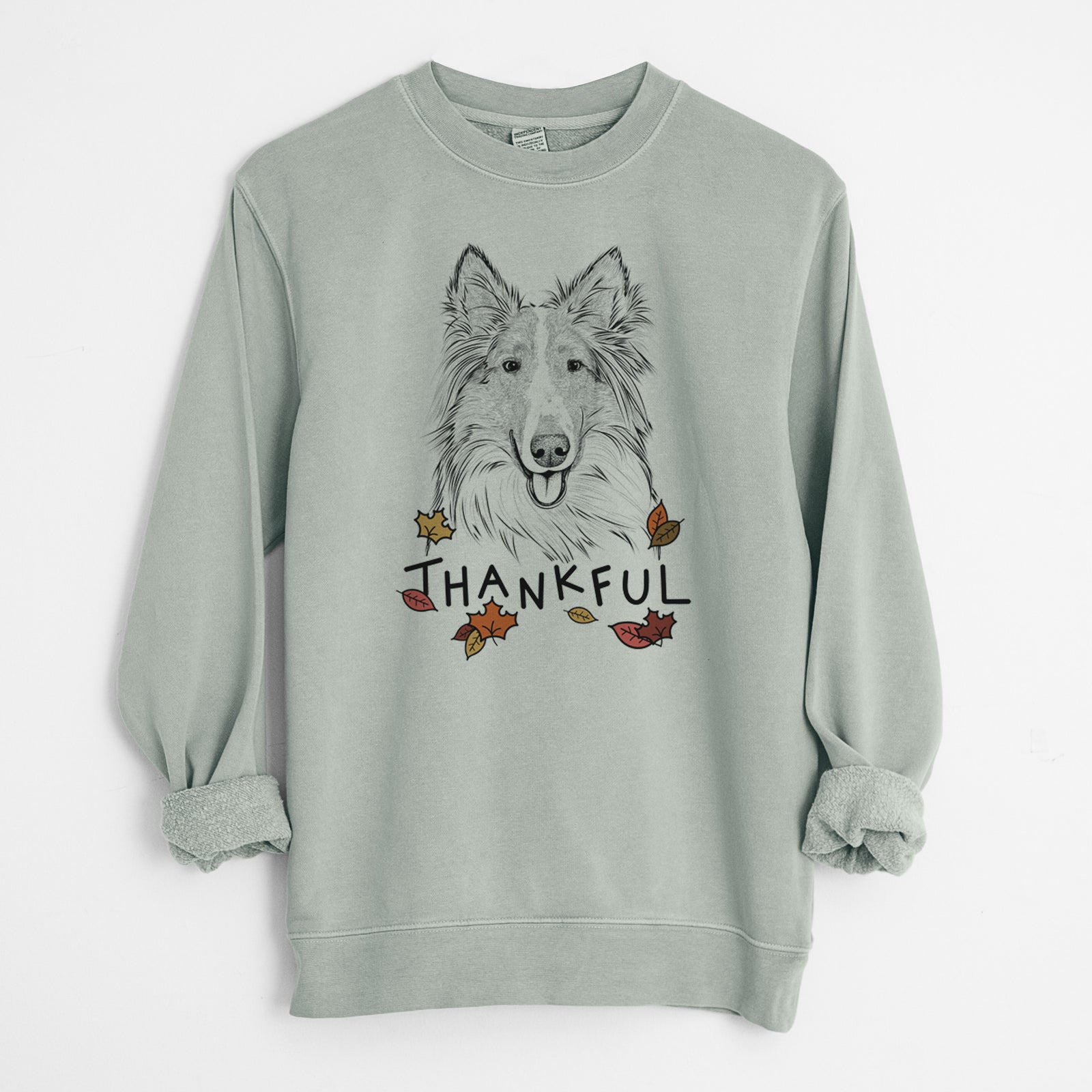 Hand-drawn sketch of Conrad the Rough Collie with 'Thankful' lettering and autumn leaves on a Sage Unisex pigment dyed crew sweatshirt