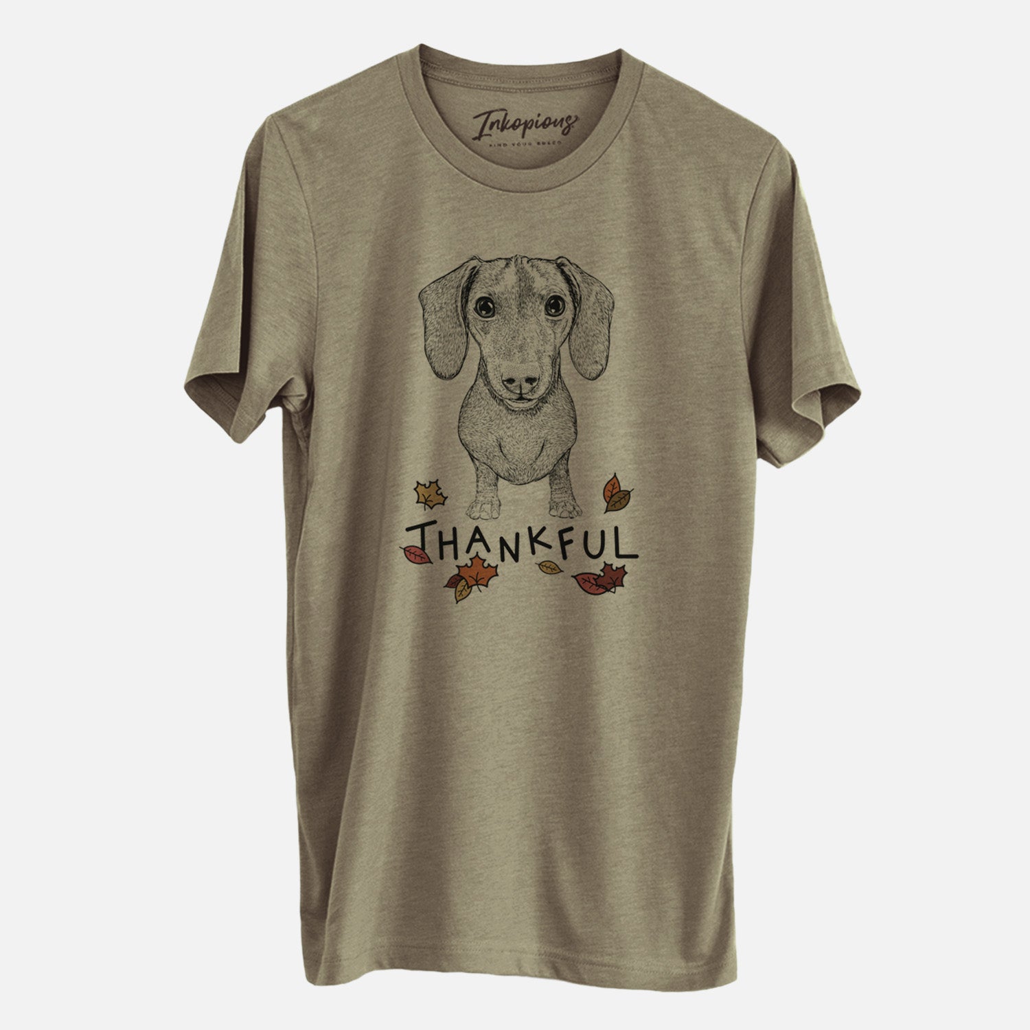 Hand-drawn sketch of Ernie the Mini Dachshund with 'Thankful' lettering and autumn leaves on an Olive Unisex crewneck