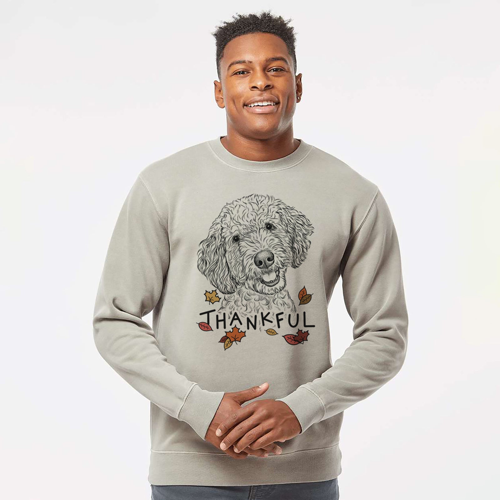 Hand-drawn sketch of Gizmo the Goldendoodle with 'Thankful' lettering and autumn leaves on a Cement Unisex pigment dyed crew sweatshirt