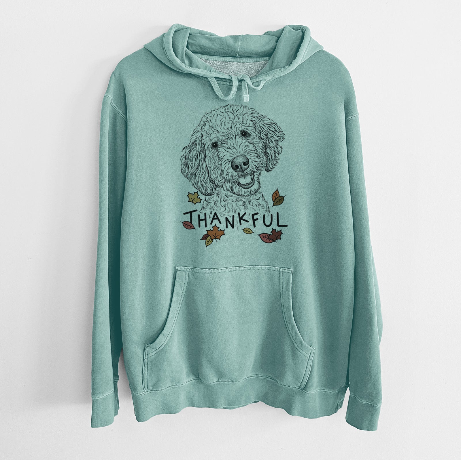 Hand-drawn sketch of Gizmo the Goldendoodle with 'Thankful' lettering and autumn leaves on a Mint Unisex pigment dyed hoodie