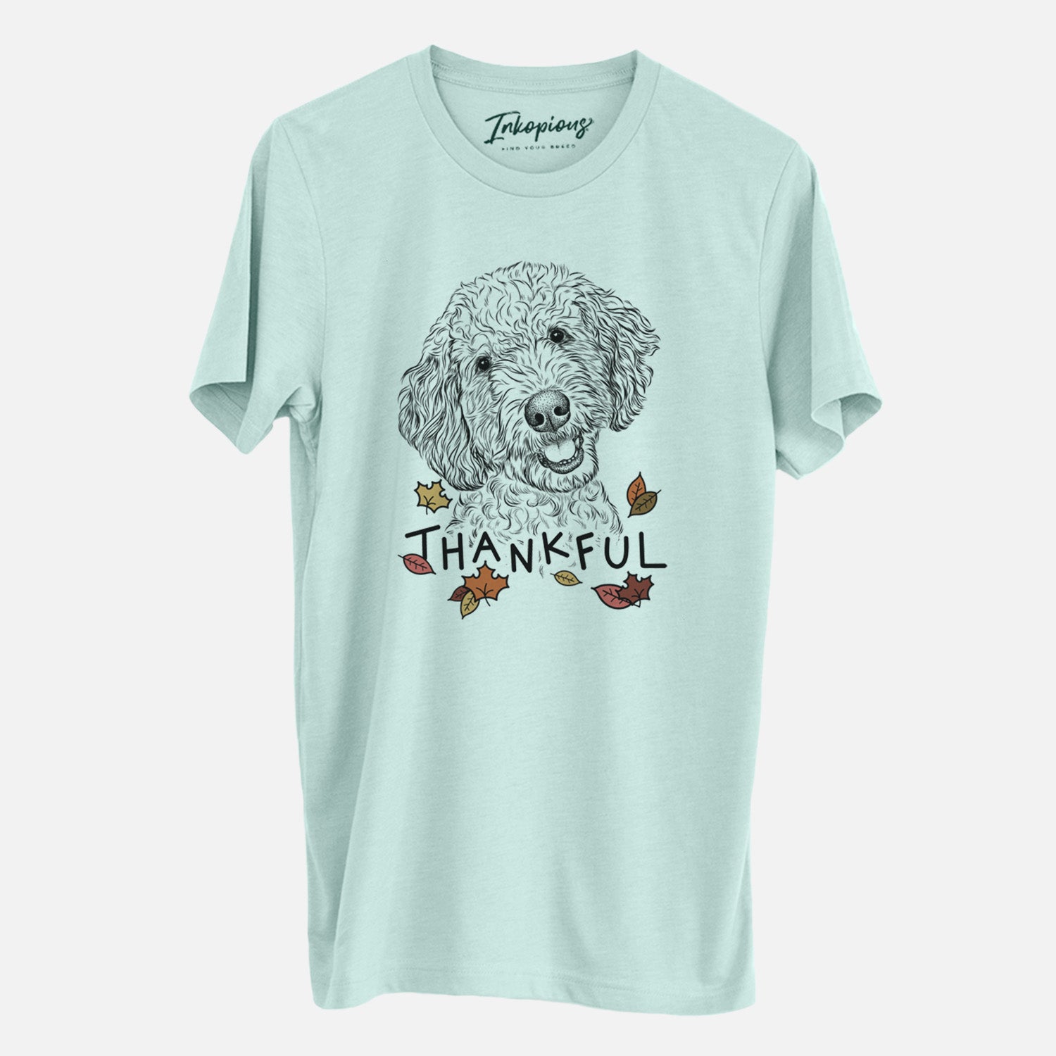 Hand-drawn sketch of Gizmo the Goldendoodle with 'Thankful' lettering and autumn leaves on a Heather Sage Unisex crewneck