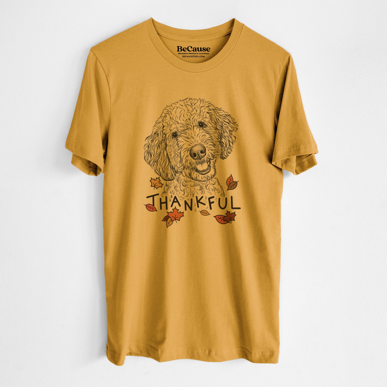 Hand-drawn sketch of Gizmo the Goldendoodle with 'Thankful' lettering and autumn leaves on a Mustard Unisex crewneck, worn by a man