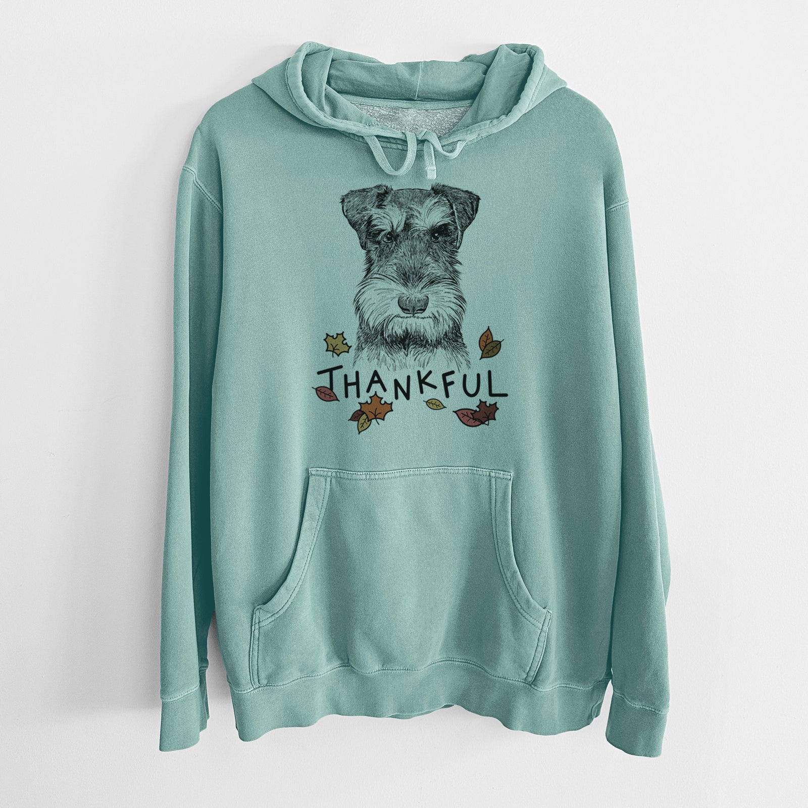 Hand-drawn sketch of Murphy the Mini Schnauzer with 'Thankful' lettering and autumn leaves on a Mint Unisex pigment dyed hoodie