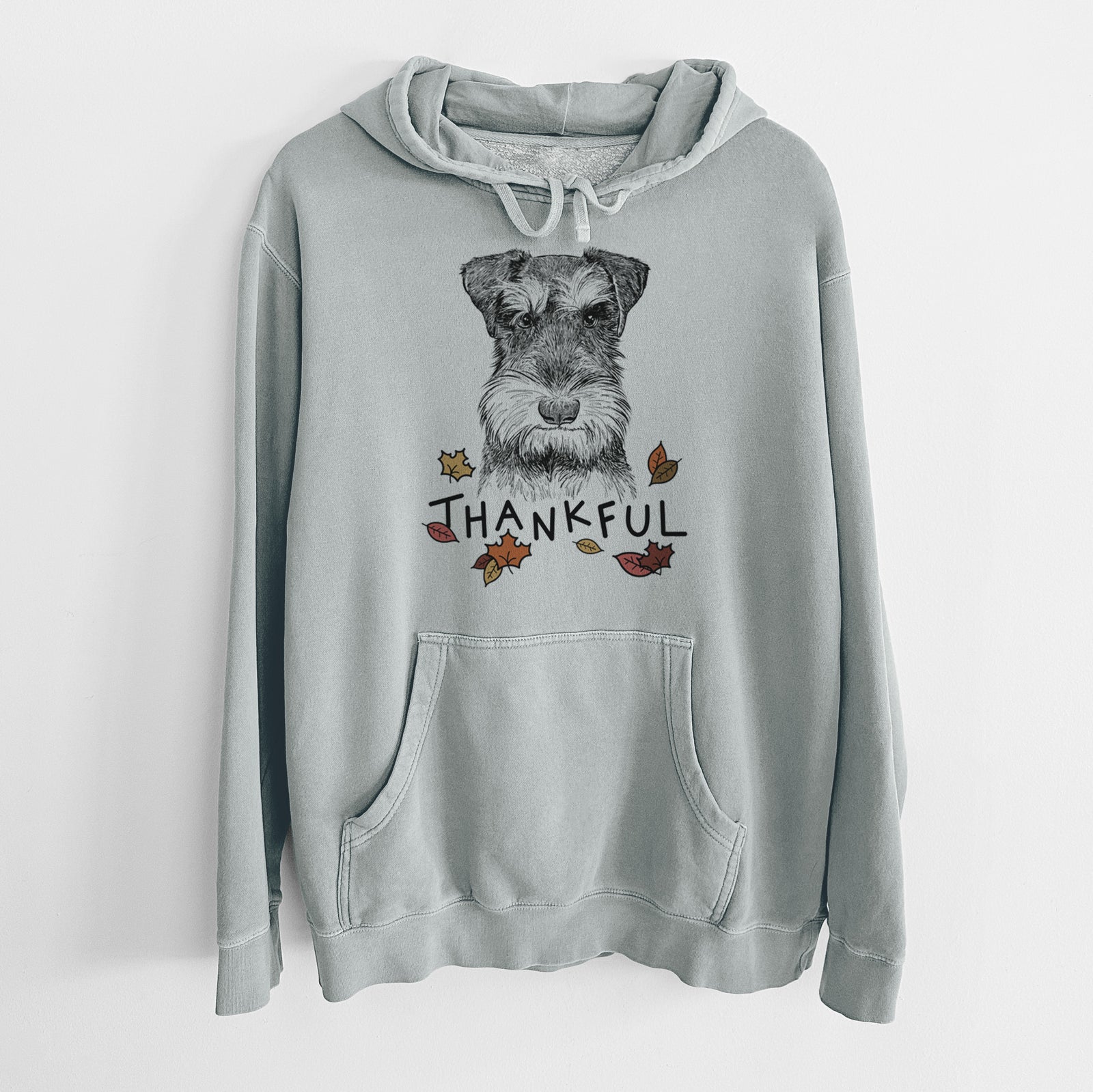 Hand-drawn sketch of Murphy the Mini Schnauzer with 'Thankful' lettering and autumn leaves on a Sage Unisex pigment dyed hoodie