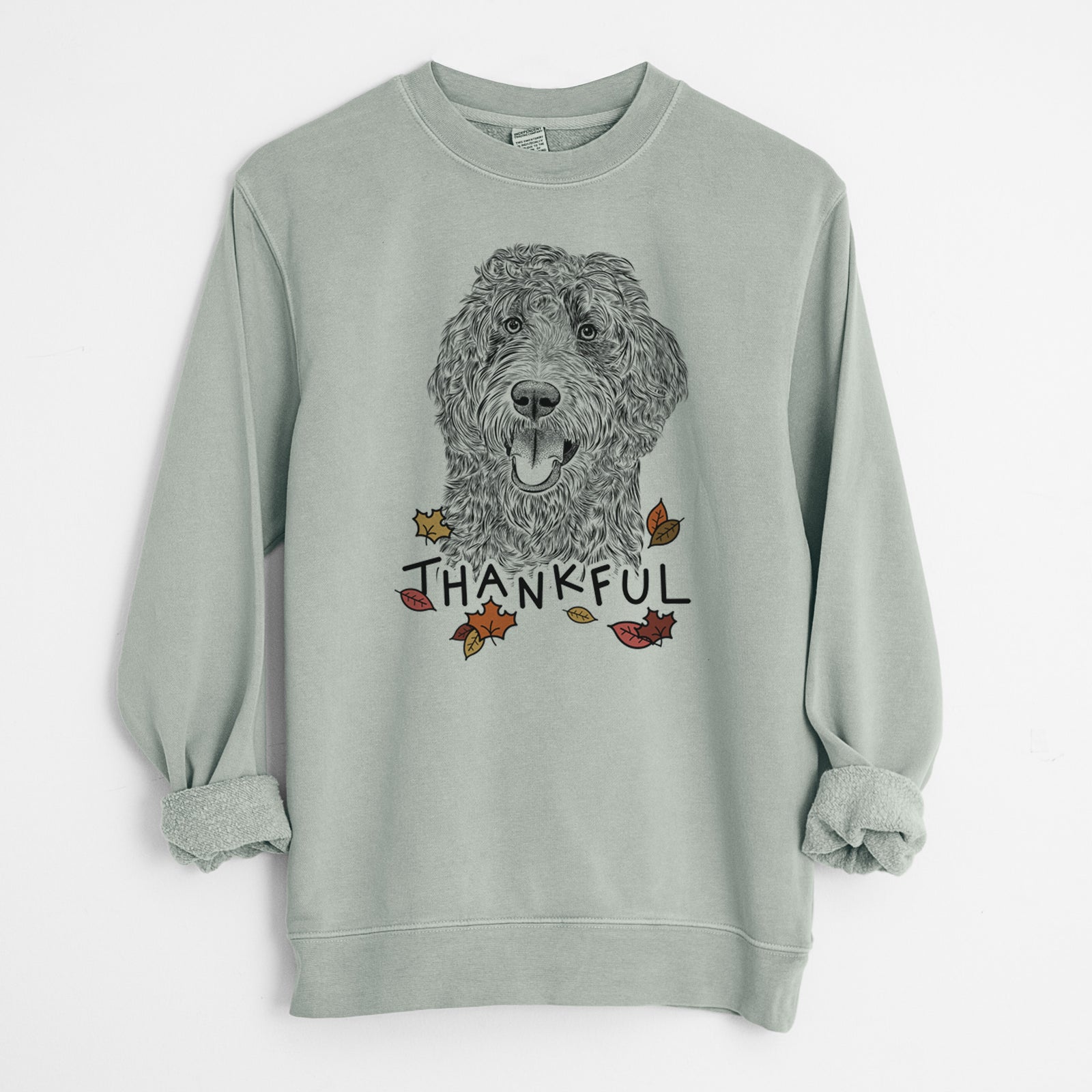 Hand-drawn sketch of Murr Dog the Labradoodle with 'Thankful' lettering and autumn leaves on a Sage Unisex pigment dyed crew sweatshirt
