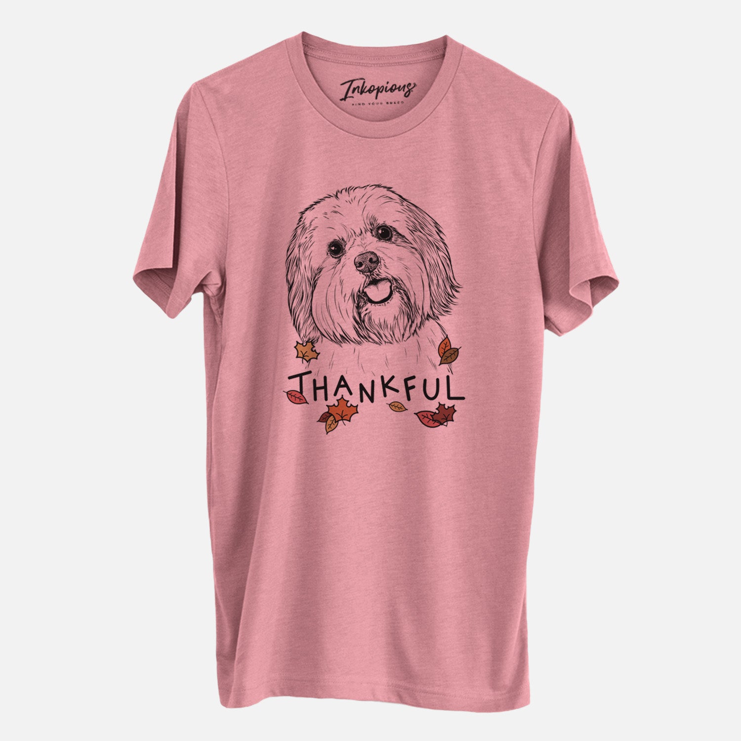 Hand-drawn sketch of Nikka the Lowchen with 'Thankful' lettering and autumn leaves on a Mauve Unisex crewneck, worn by a man