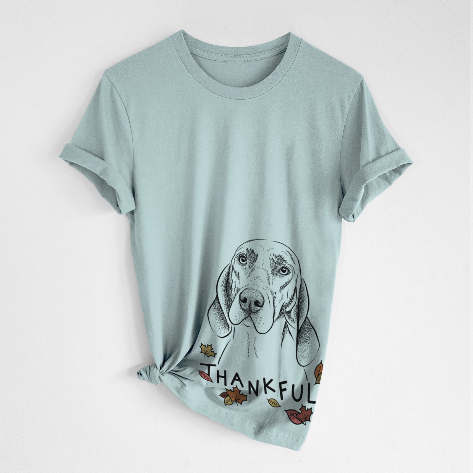 Hand-drawn sketch of Norman the Plott Hound with 'Thankful' lettering and autumn leaves on a Dusty Blue Unisex crewneck, worn by a woman