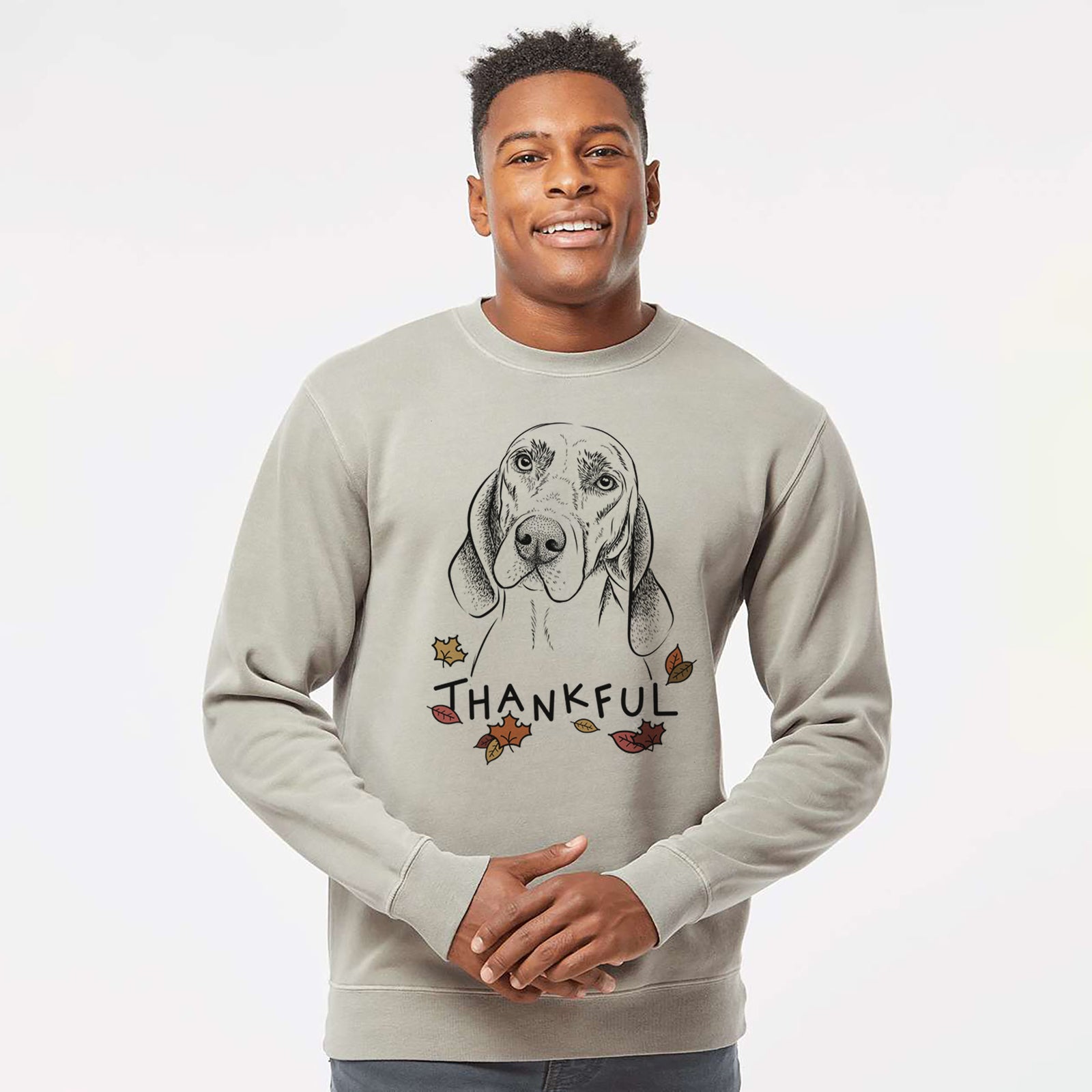 Hand-drawn sketch of Norman the Plott Hound with 'Thankful' lettering and autumn leaves on a Cement Unisex pigment dyed crew sweatshirt