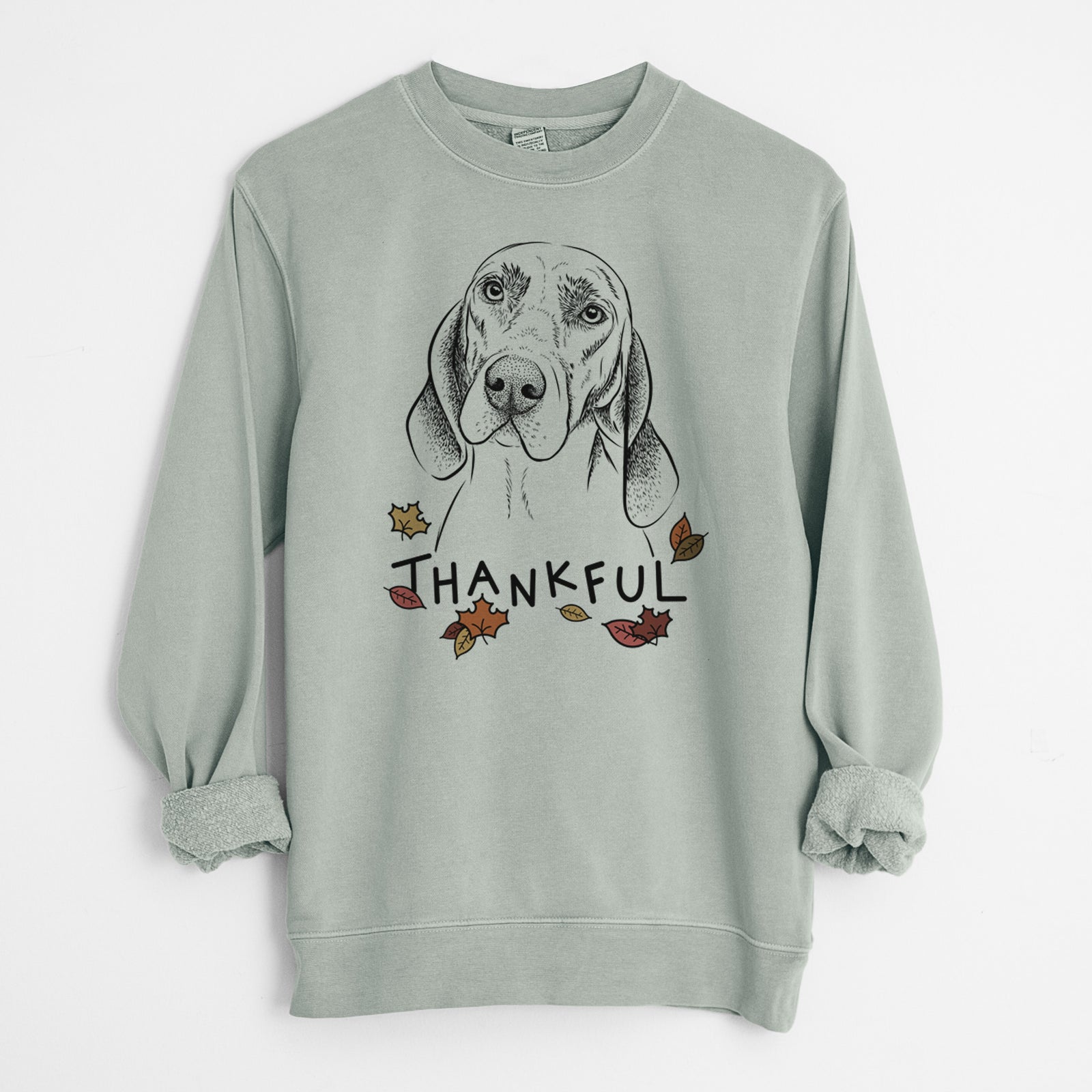 Hand-drawn sketch of Norman the Plott Hound with 'Thankful' lettering and autumn leaves on a Sage Unisex pigment dyed crew sweatshirt