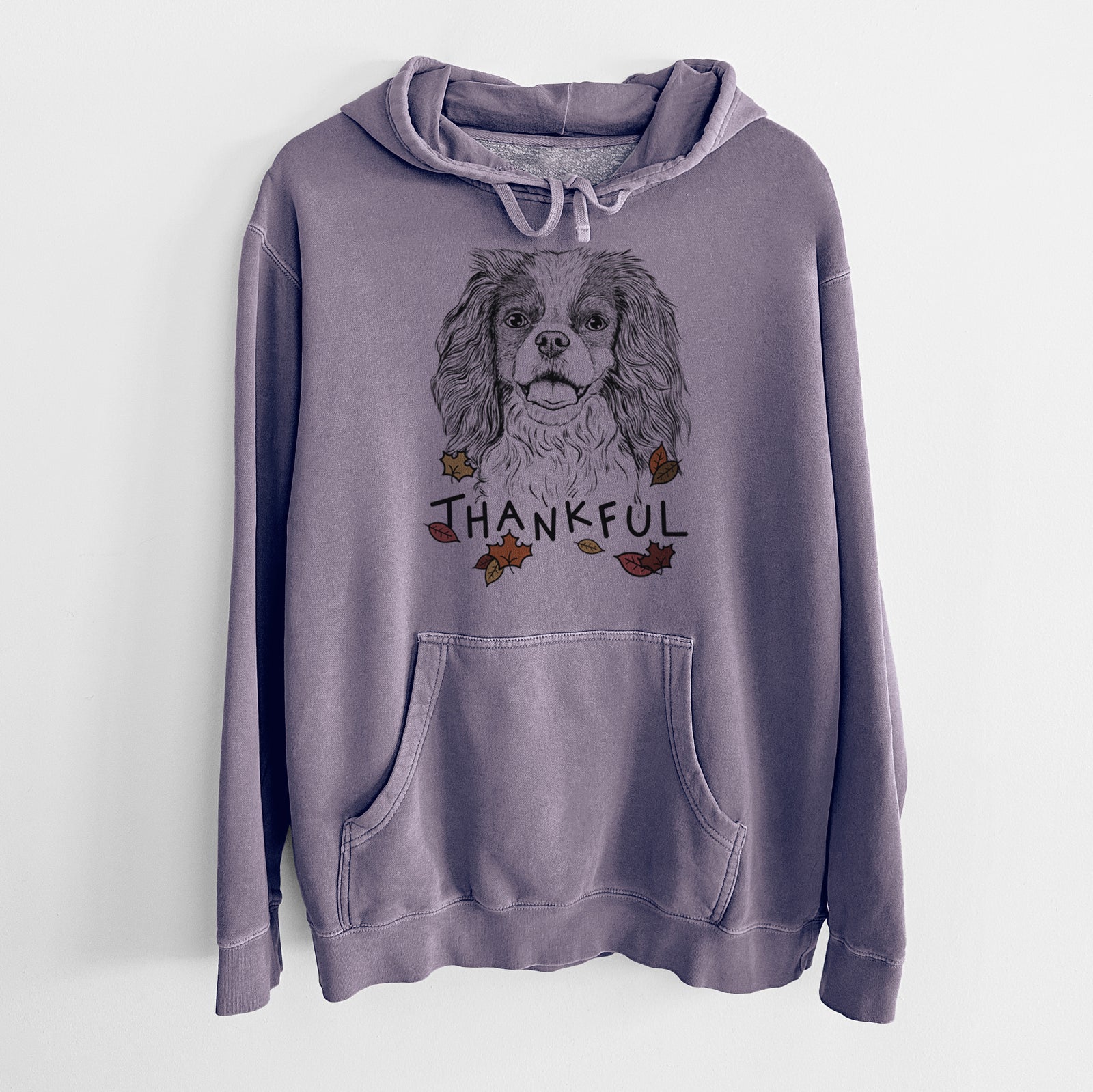 Hand-drawn sketch of Poppy the Cavalier King Charles Spaniel with 'Thankful' lettering and autumn leaves on a Plum Unisex pigment dyed hoodie