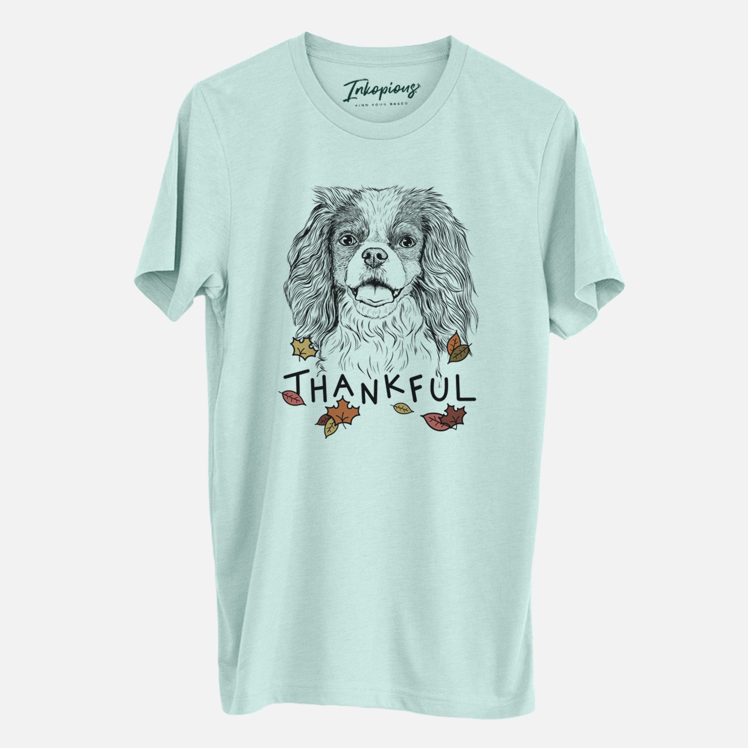 Hand-drawn sketch of Poppy the Cavalier King Charles Spaniel with 'Thankful' lettering and autumn leaves on a Heather Sage Unisex crewneck