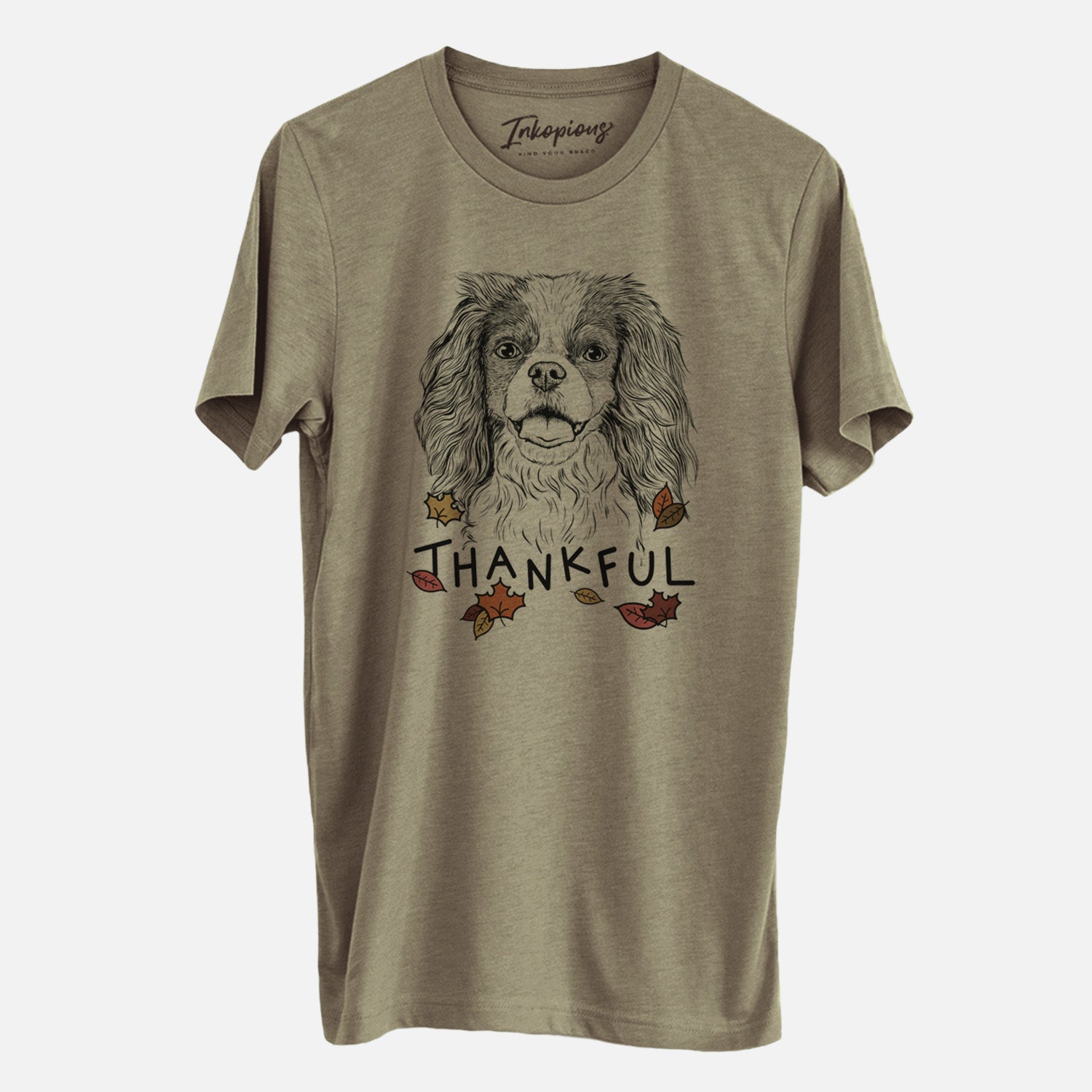 Hand-drawn sketch of Poppy the Cavalier King Charles Spaniel with 'Thankful' lettering and autumn leaves on an Olive Unisex crewneck