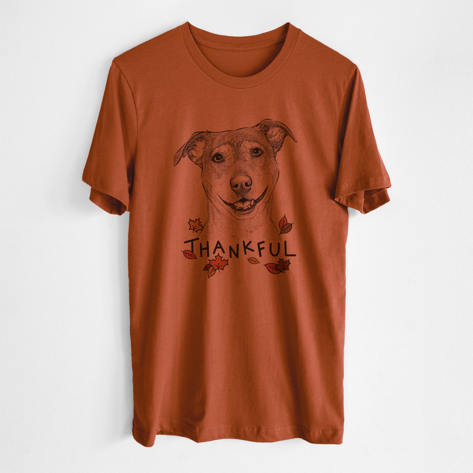 Hand-drawn sketch of Reese the Mountain Cur with 'Thankful' lettering and autumn leaves on an Autumn Unisex crewneck, worn by a man