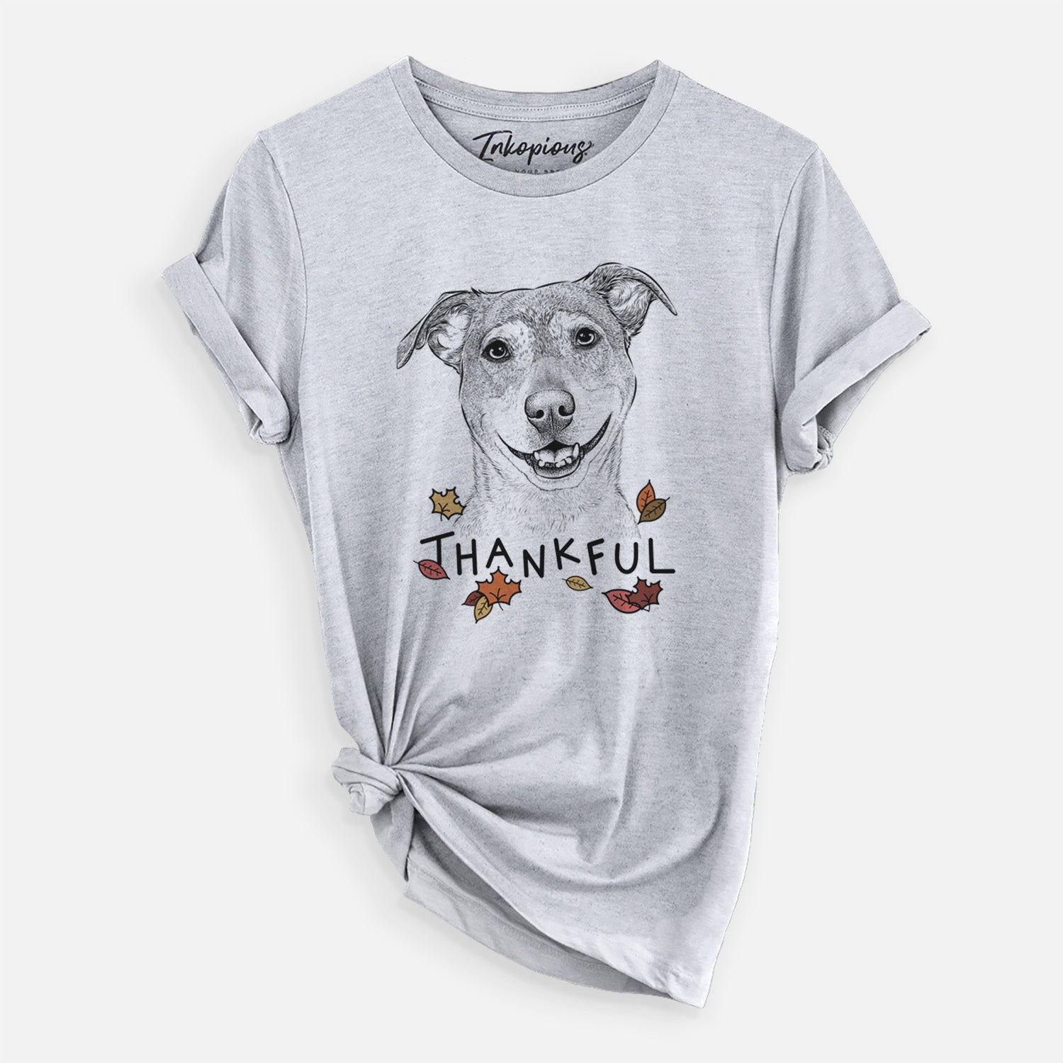Hand-drawn sketch of Reese the Mountain Cur with 'Thankful' lettering and autumn leaves on a Grey Unisex crewneck, worn by a woman