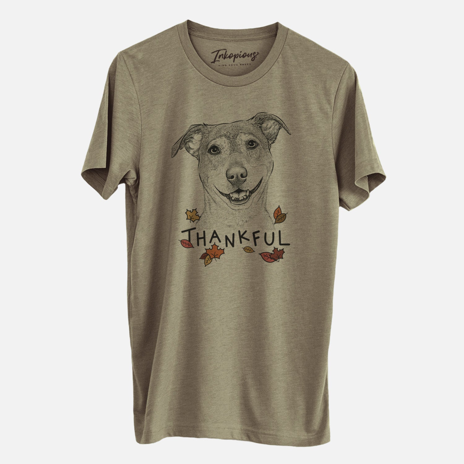 Hand-drawn sketch of Reese the Mountain Cur with 'Thankful' lettering and autumn leaves on an Olive Unisex crewneck, worn by a man