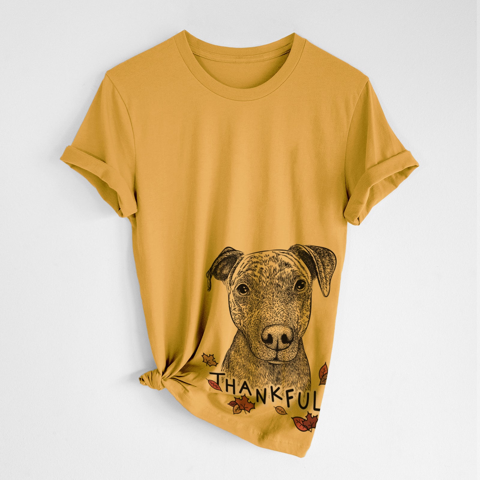 Hand-drawn sketch of Reeses the Pitbull with 'Thankful' lettering and autumn leaves on a Mustard Unisex crewneck, worn by a woman