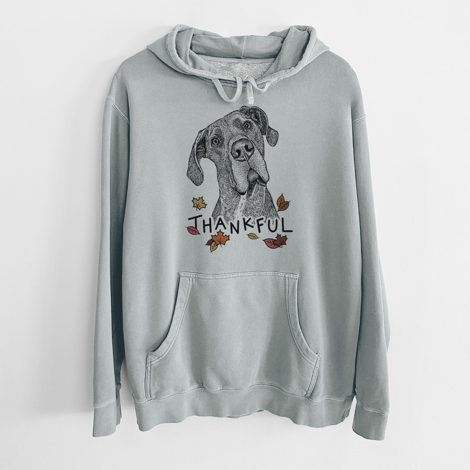 Hand-drawn sketch of River the Great Dane with 'Thankful' lettering and autumn leaves on a Sage Unisex pigment dyed hoodie