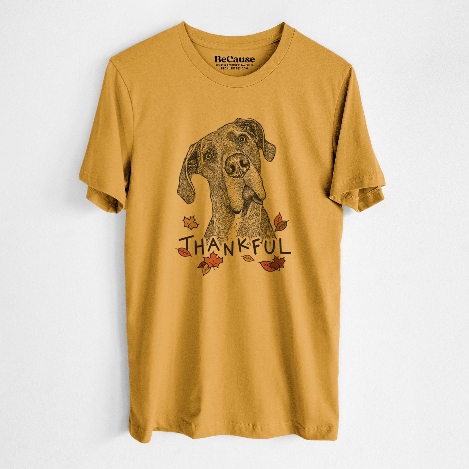 Hand-drawn sketch of River the Great Dane with 'Thankful' lettering and autumn leaves on a Mustard Unisex crewneck, worn by a man