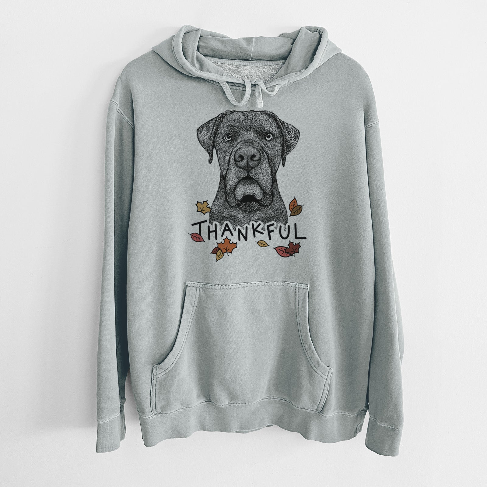 Hand-drawn sketch of Rocco the Cane Corso with 'Thankful' lettering and autumn leaves on a Sage Unisex pigment dyed hoodie