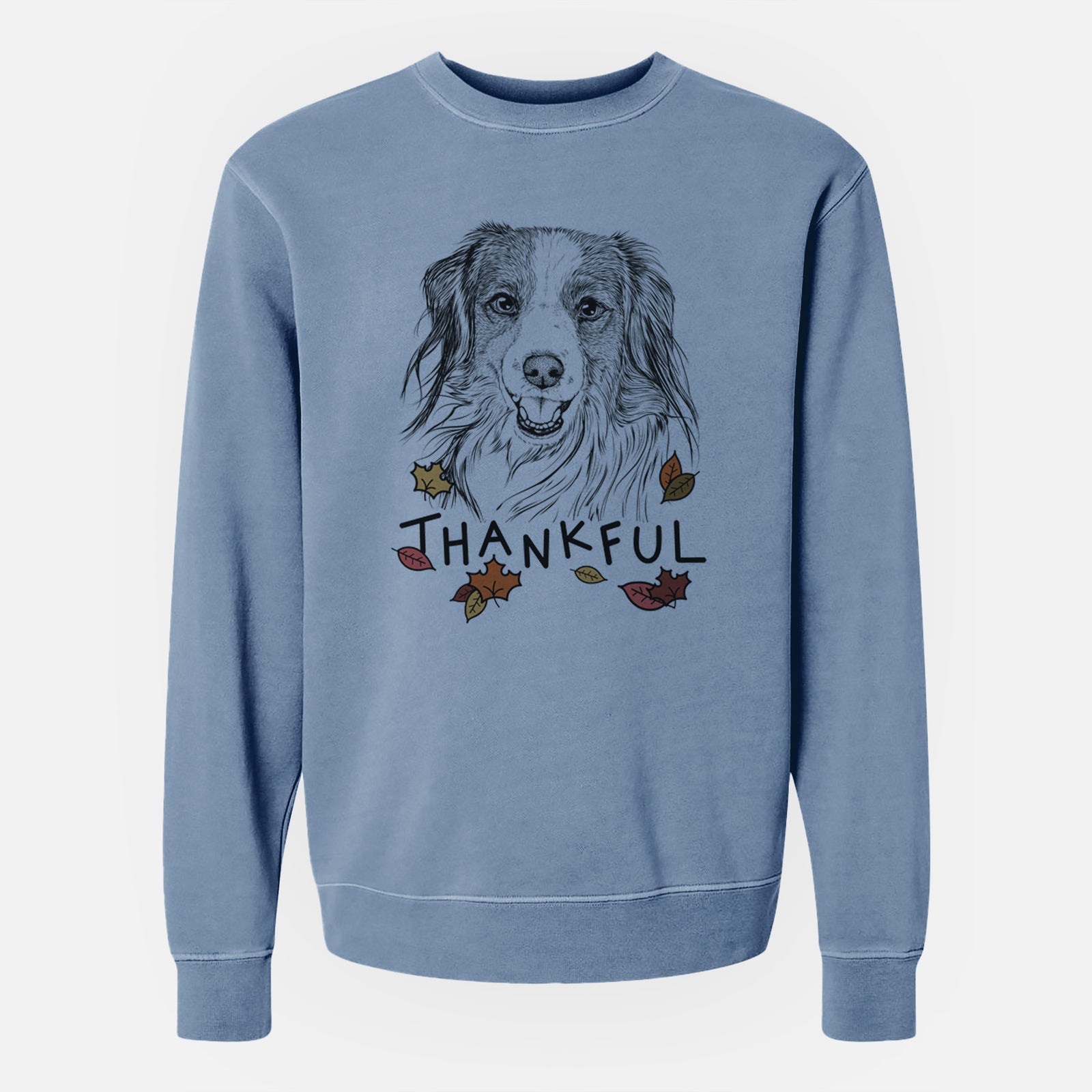 Hand-drawn sketch of Rutger the Nederlandse Kooikerhondje with 'Thankful' lettering and autumn leaves on a Slate Blue Unisex pigment dyed crew sweatshirt