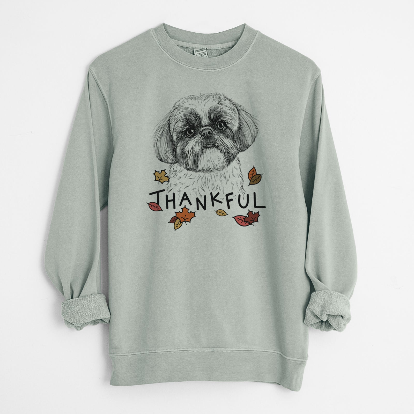 Hand-drawn sketch of Simon the Shih Tzu with 'Thankful' lettering and autumn leaves on a Sage Unisex pigment dyed crew sweatshirt