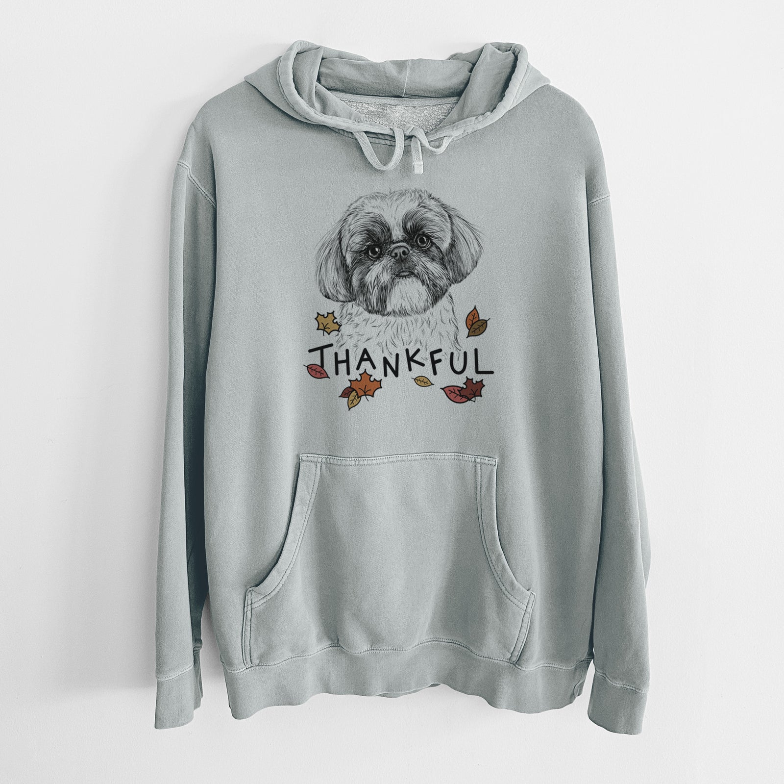 Hand-drawn sketch of Simon the Shih Tzu with 'Thankful' lettering and autumn leaves on a Sage Unisex pigment dyed hoodie