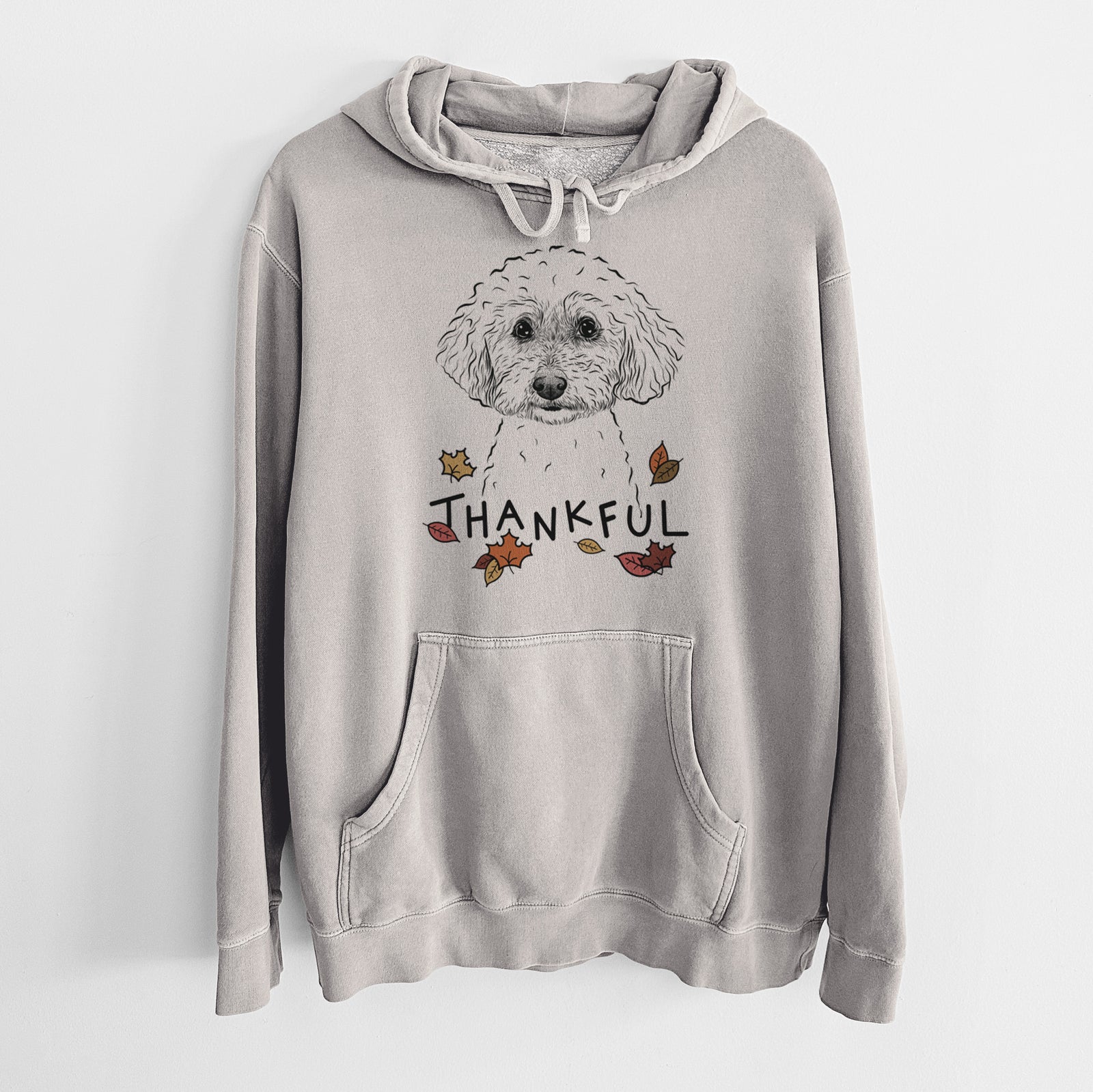 Hand-drawn sketch of Stitch the Bichonpoo with 'Thankful' lettering and autumn leaves on a Cement Unisex pigment dyed hoodie