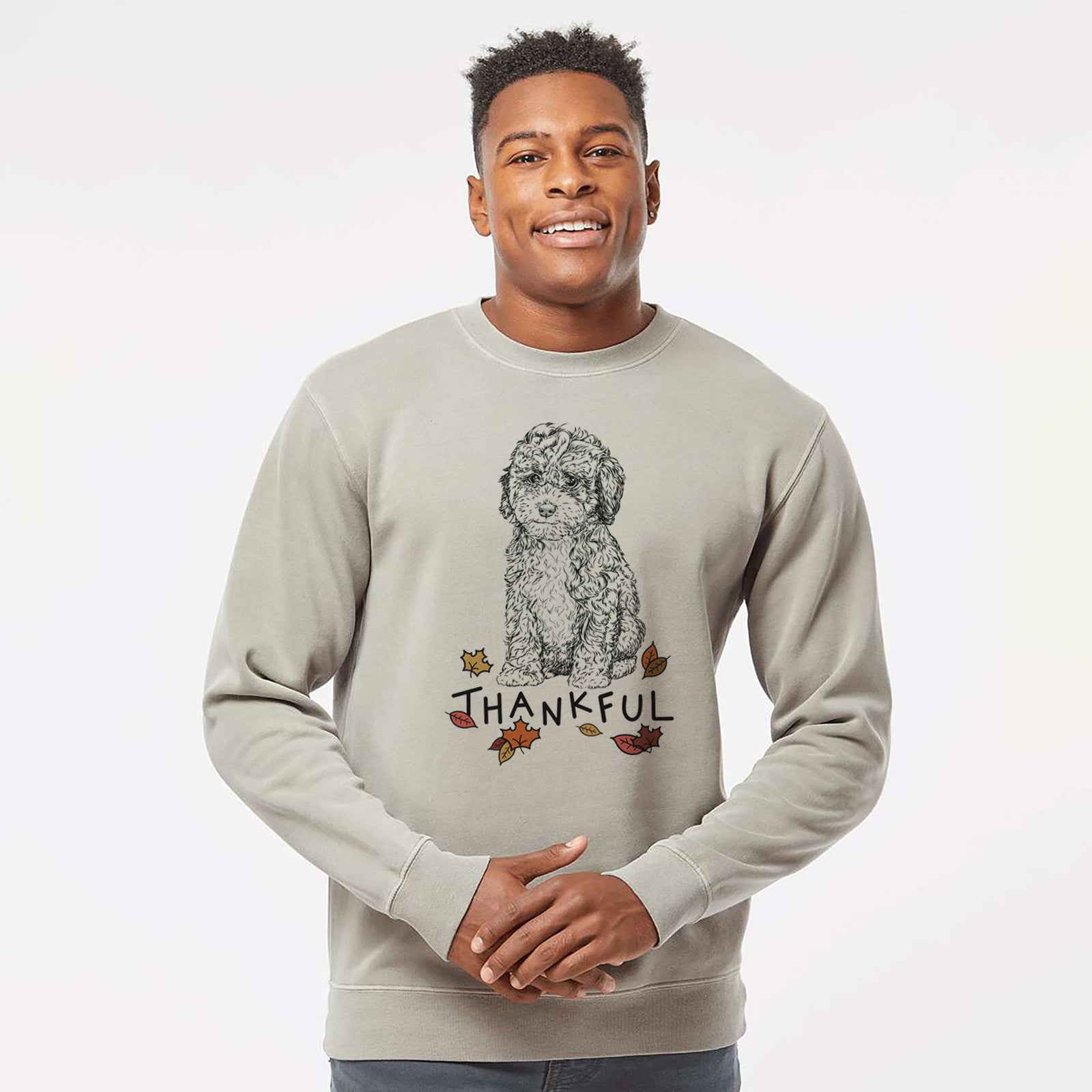 Hand-drawn sketch of Sweet Tea the Mini Doodle with 'Thankful' lettering and autumn leaves on a Cement Unisex pigment dyed crew sweatshirt