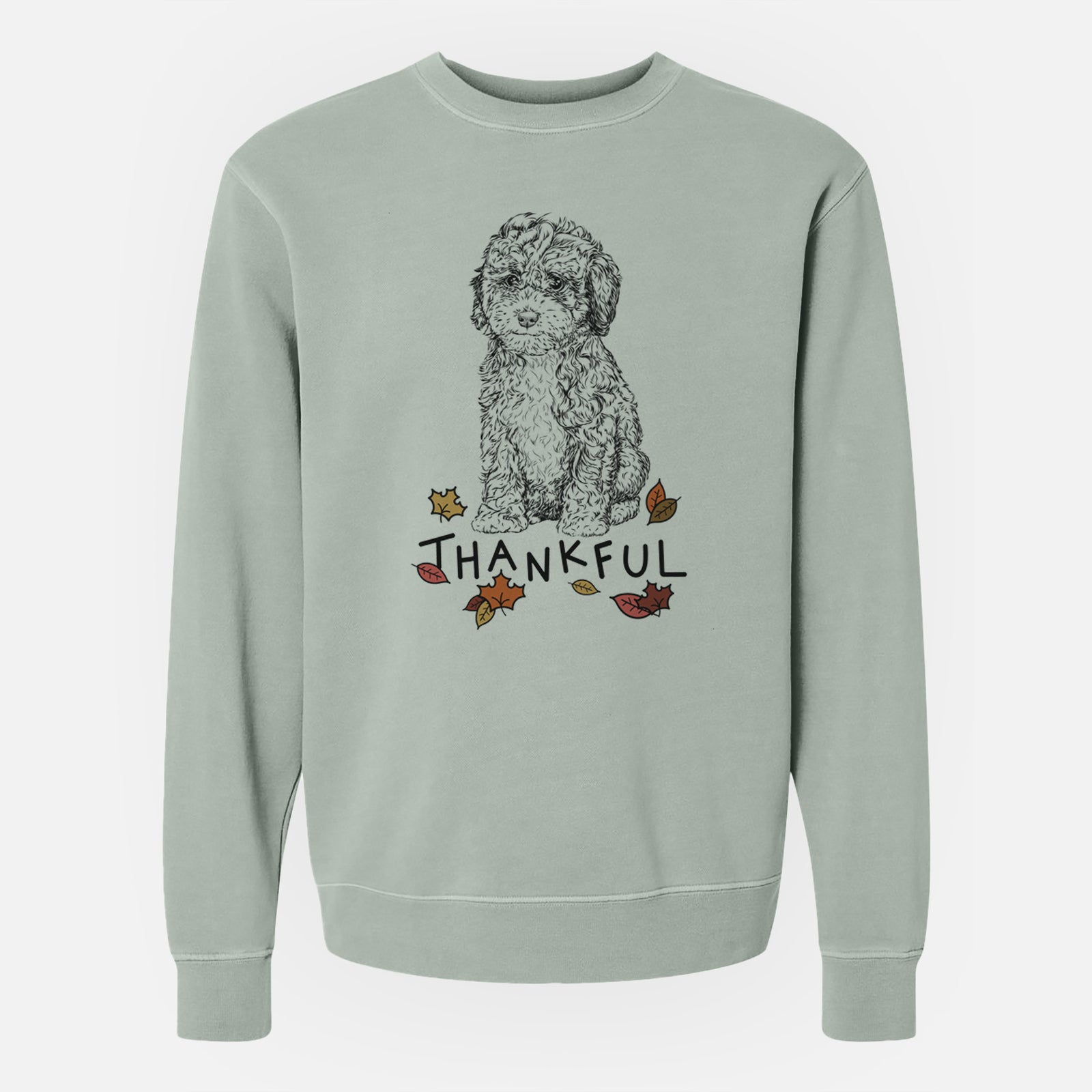 Hand-drawn sketch of Sweet Tea the Mini Doodle with 'Thankful' lettering and autumn leaves on a Sage Unisex pigment dyed crew sweatshirt