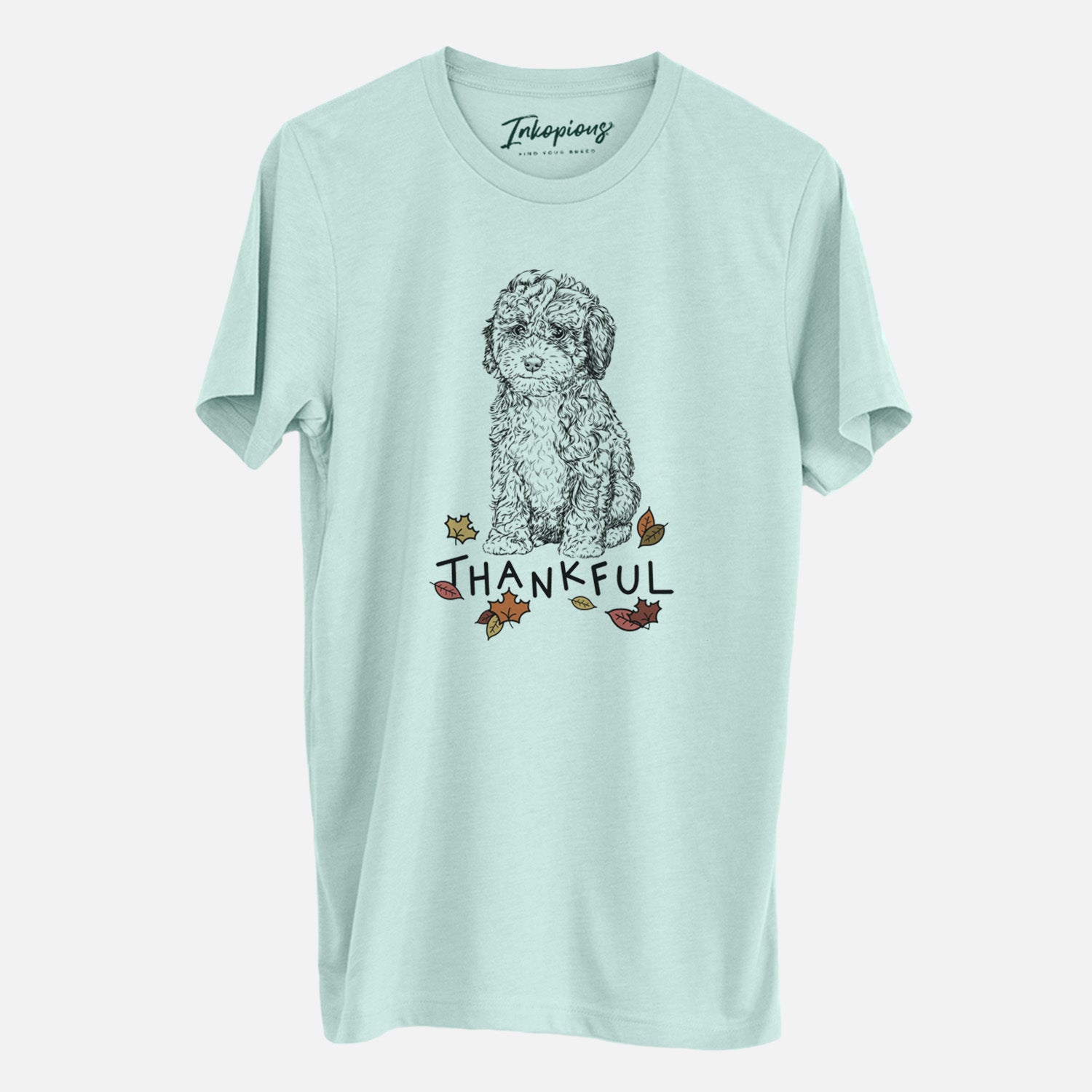 Hand-drawn sketch of Sweet Tea the Mini Doodle with 'Thankful' lettering and autumn leaves on a Heather Sage Unisex crewneck
