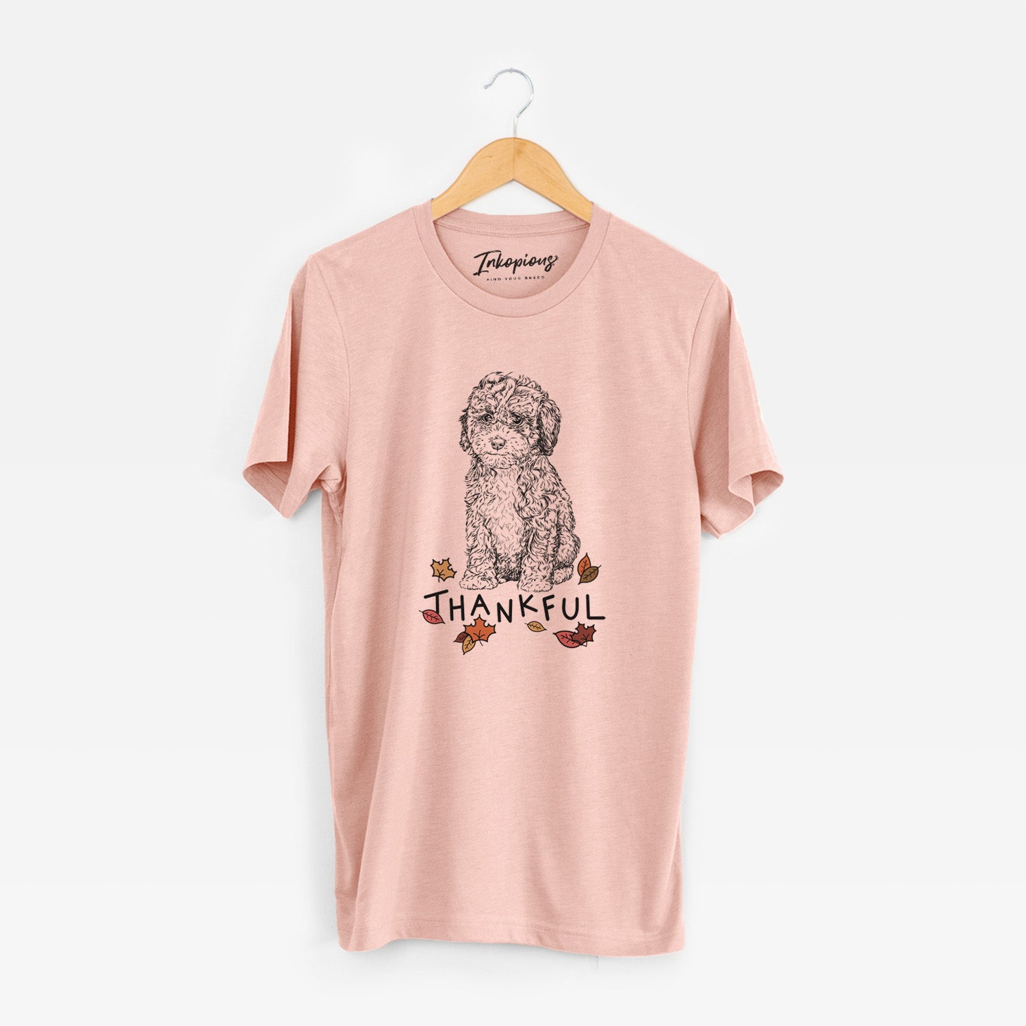 Hand-drawn sketch of Sweet Tea the Mini Doodle with 'Thankful' lettering and autumn leaves on a Peach Unisex crewneck
