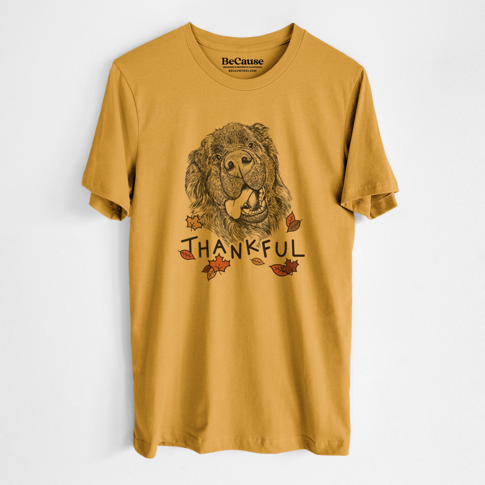 Hand-drawn sketch of Tuna the Newfoundland with 'Thankful' lettering and autumn leaves on a Mustard Unisex crewneck, worn by a man