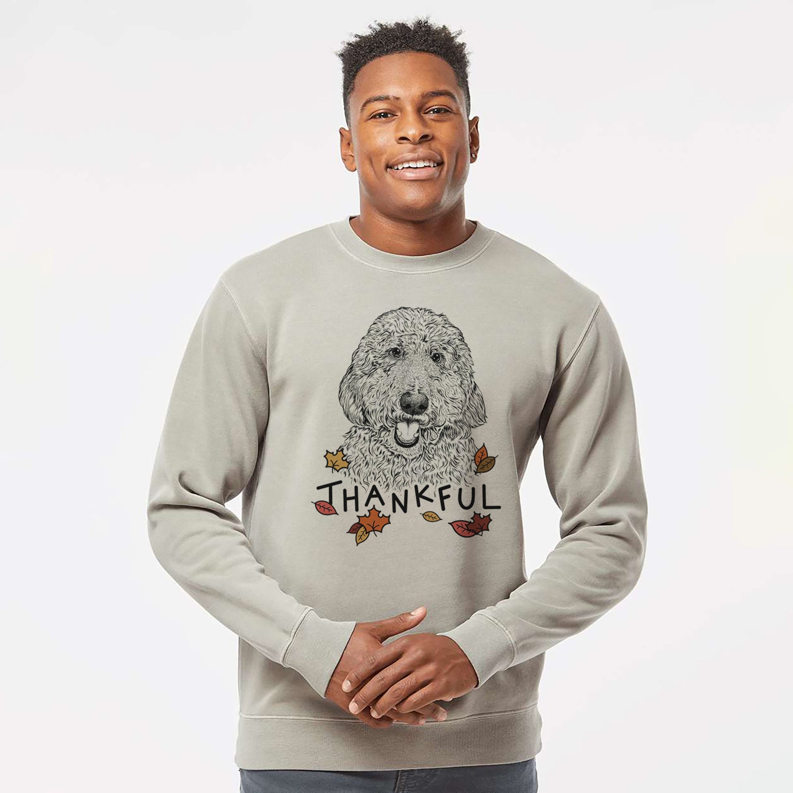Hand-drawn sketch of Whisper the Goldendoodle with 'Thankful' lettering and autumn leaves on a Cement Unisex pigment dyed crew sweatshirt