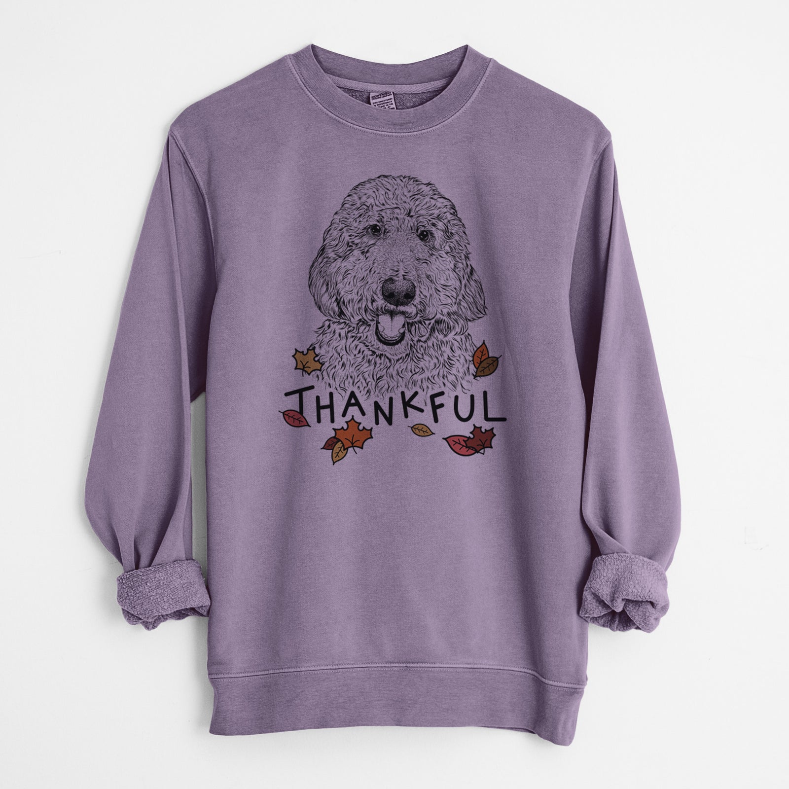Hand-drawn sketch of Whisper the Goldendoodle with 'Thankful' lettering and autumn leaves on a Plum Unisex pigment dyed crew sweatshirt