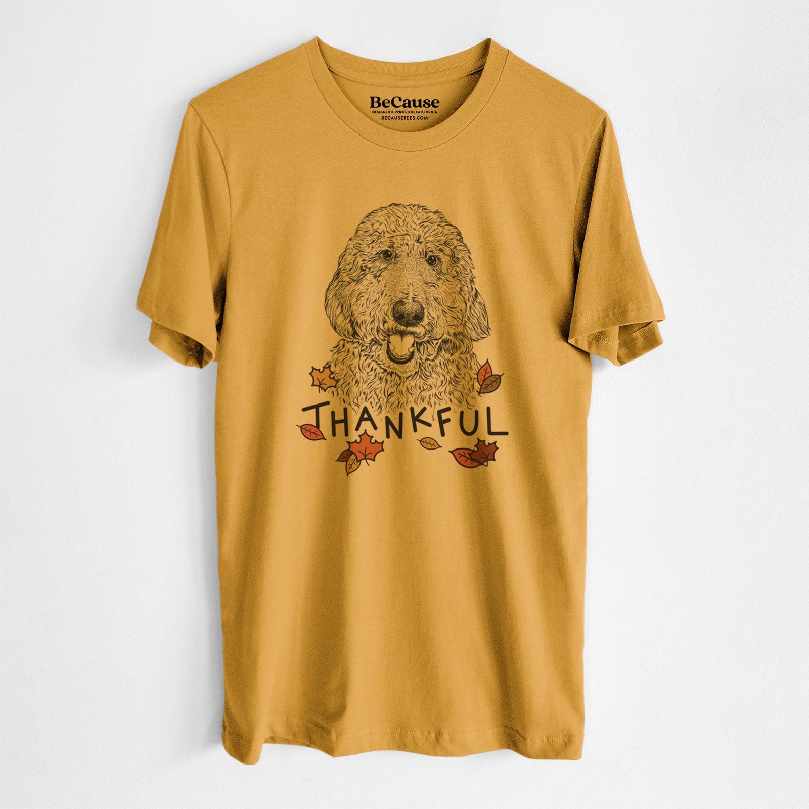 Hand-drawn sketch of Whisper the Goldendoodle with 'Thankful' lettering and autumn leaves on a Mustard Unisex crewneck, worn by a man