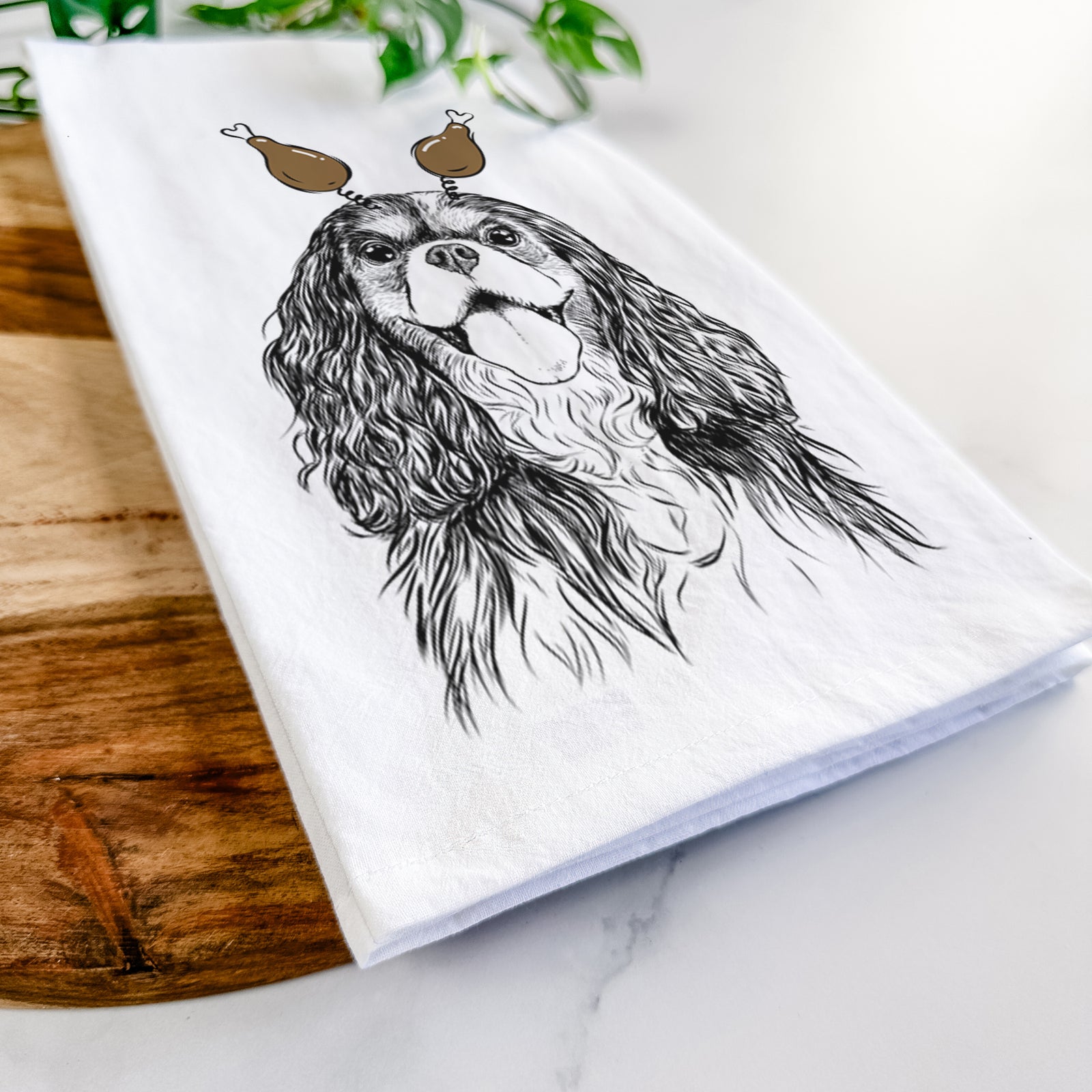 Hand-drawn sketch of Brandy the Cavalier King Charles Spaniel with a Thanksgiving turkey headpiece on a tea towel