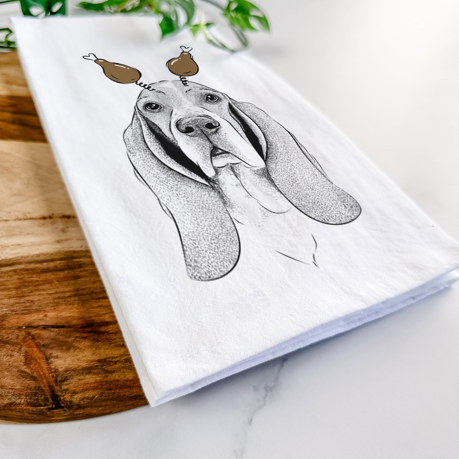 Hand-drawn sketch of Buckley the Basset Hound with a Thanksgiving turkey headpiece on a tea towel