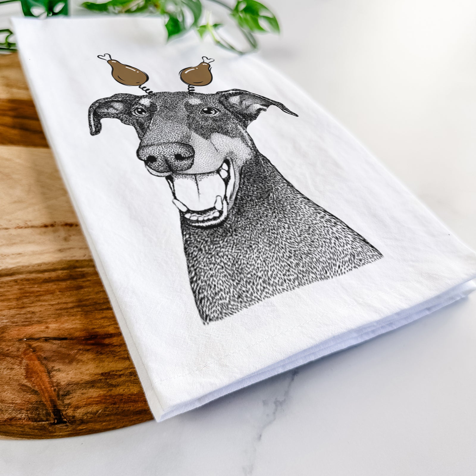 Hand-drawn sketch of Bunnie the Doberman Pinscher with a Thanksgiving turkey headpiece on a tea towel