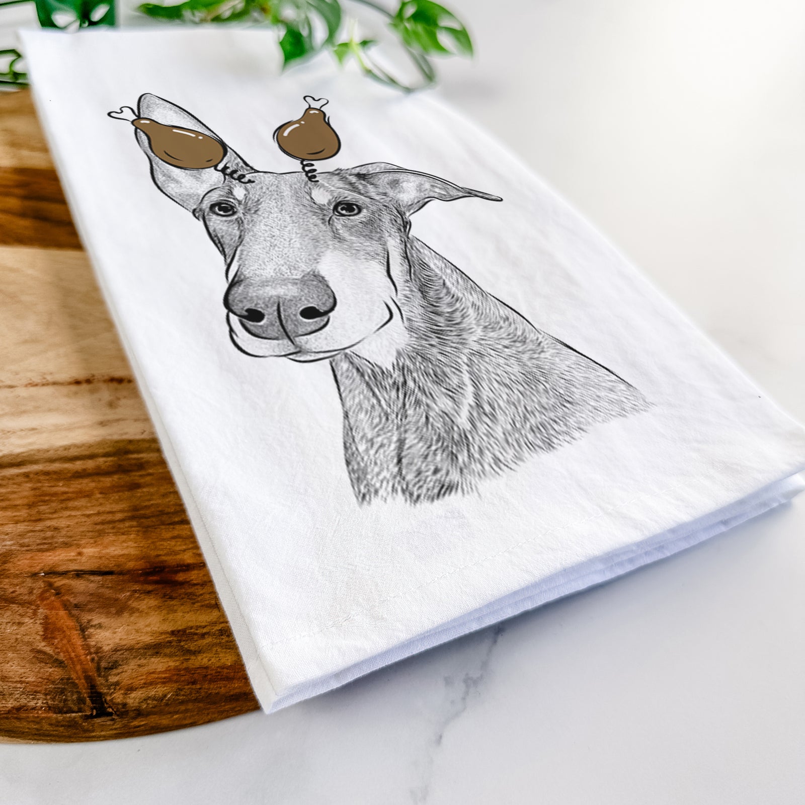 Hand-drawn sketch of Kain the Doberman Pinscher with a Thanksgiving turkey headpiece on a tea towel
