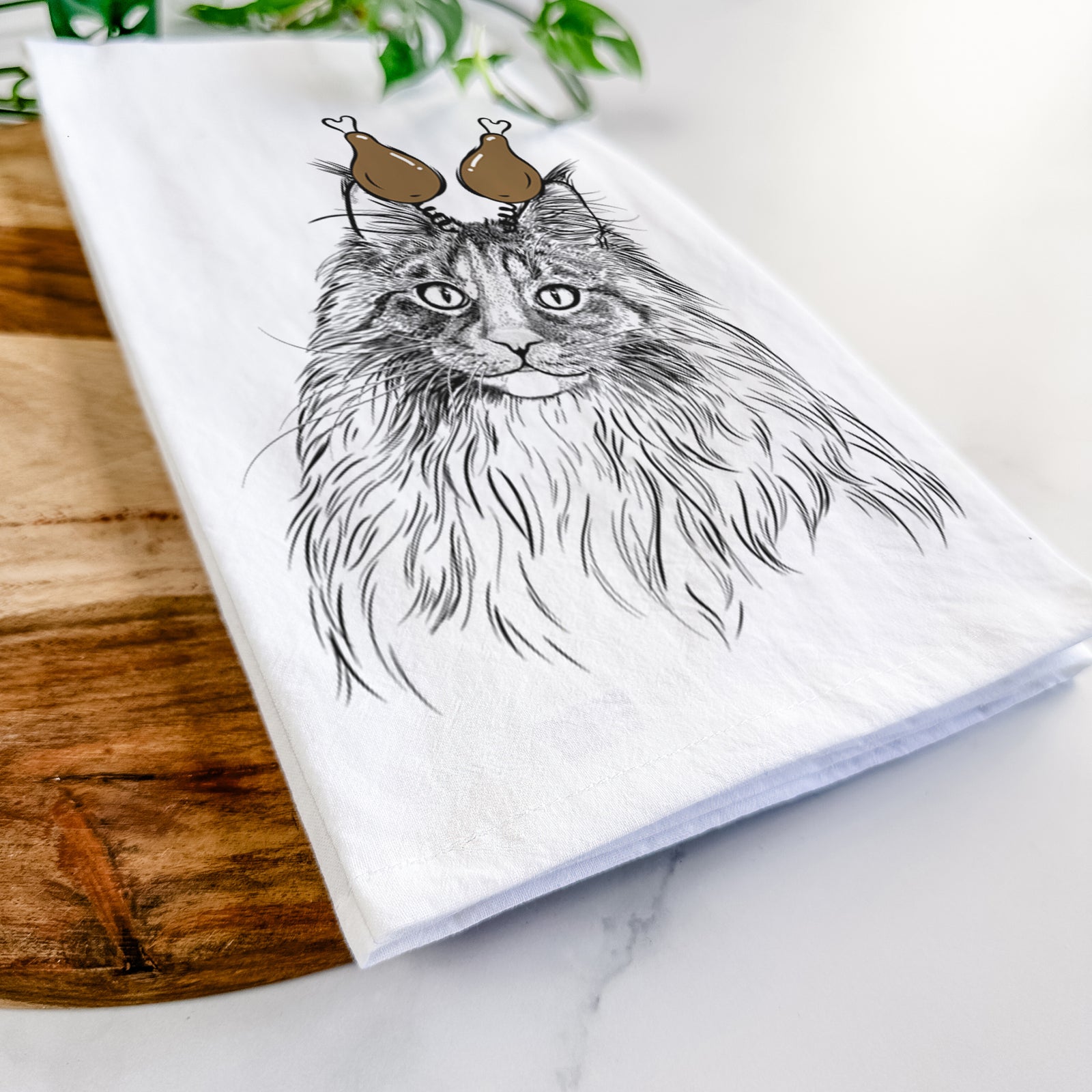 Hand-drawn sketch of Kiki the Maine Coon Cat with a Thanksgiving turkey headpiece on a tea towel