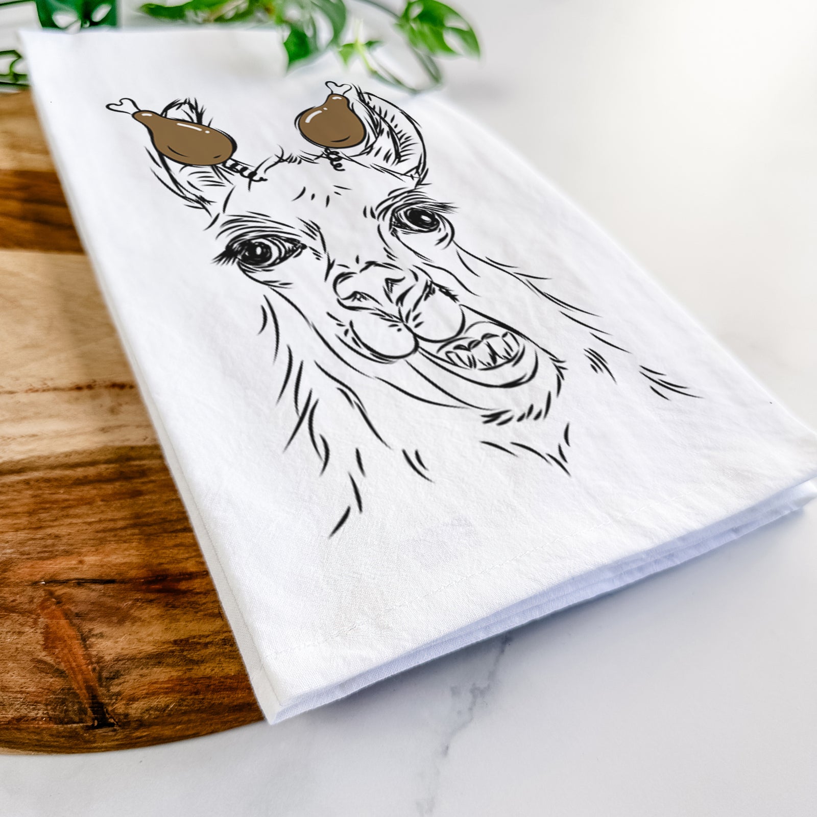 Hand-drawn sketch of Larry the Llama with a Thanksgiving turkey headpiece on a tea towel
