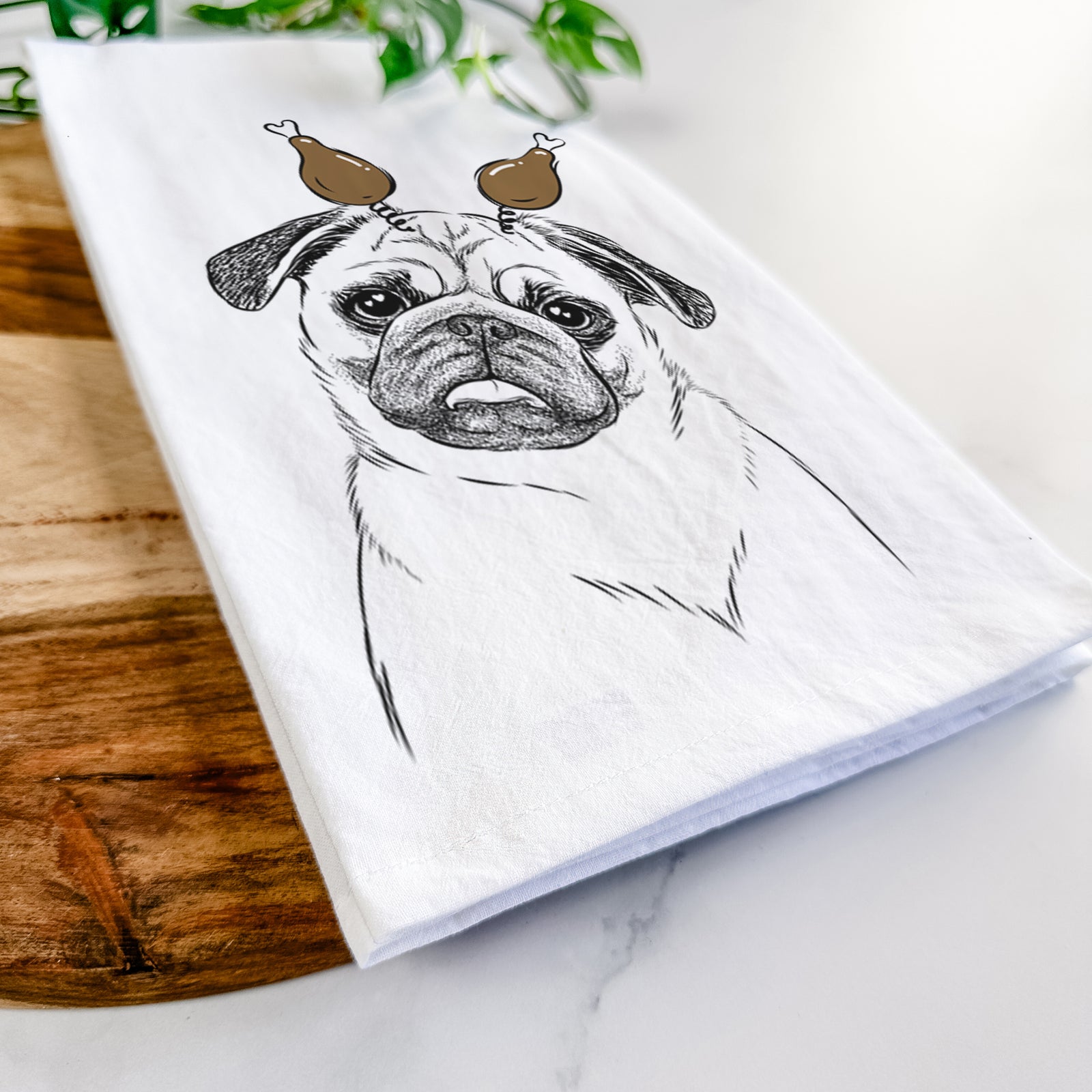 Hand-drawn sketch of Macy the Pug with a Thanksgiving turkey headpiece on a tea towel