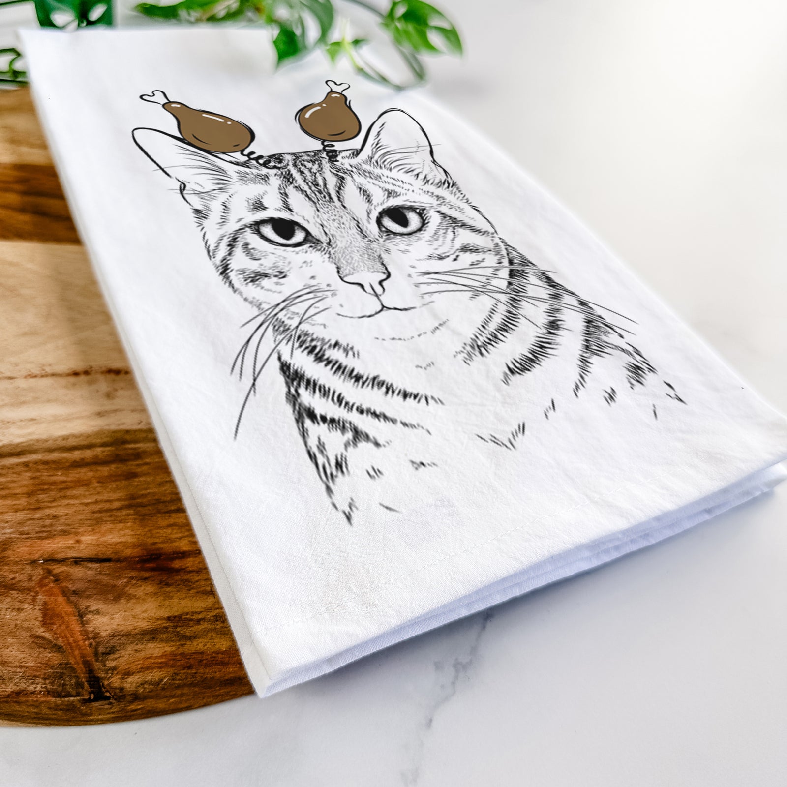 Hand-drawn sketch of Nell the Tabby Cat with a Thanksgiving turkey headpiece on a tea towel