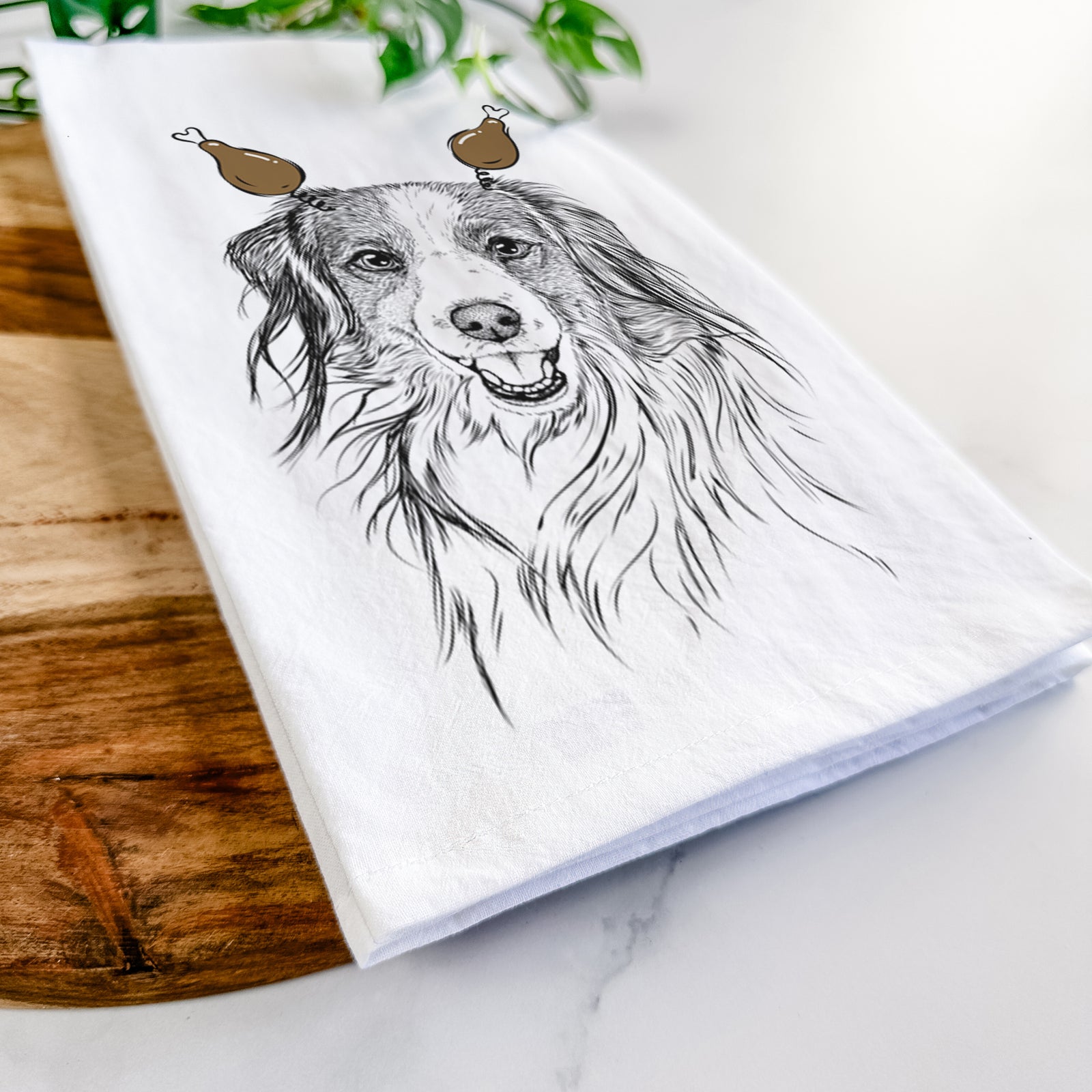 Hand-drawn sketch of Rutger the Nederlandse Kooikerhondje with a Thanksgiving turkey headpiece on a tea towel