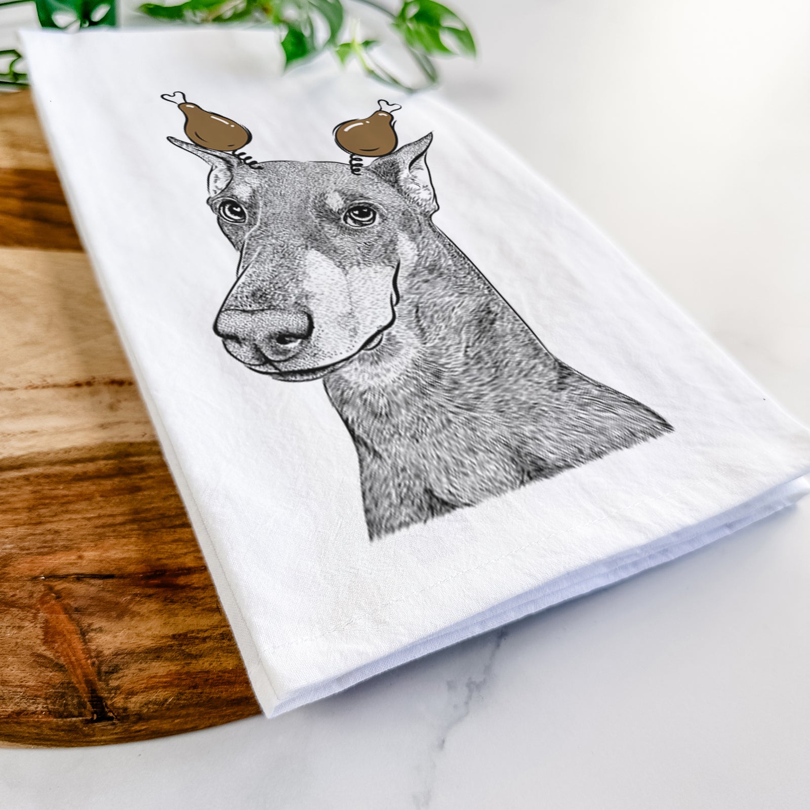 Hand-drawn sketch of Shelby the Doberman Pinscher with a Thanksgiving turkey headpiece on a tea towel